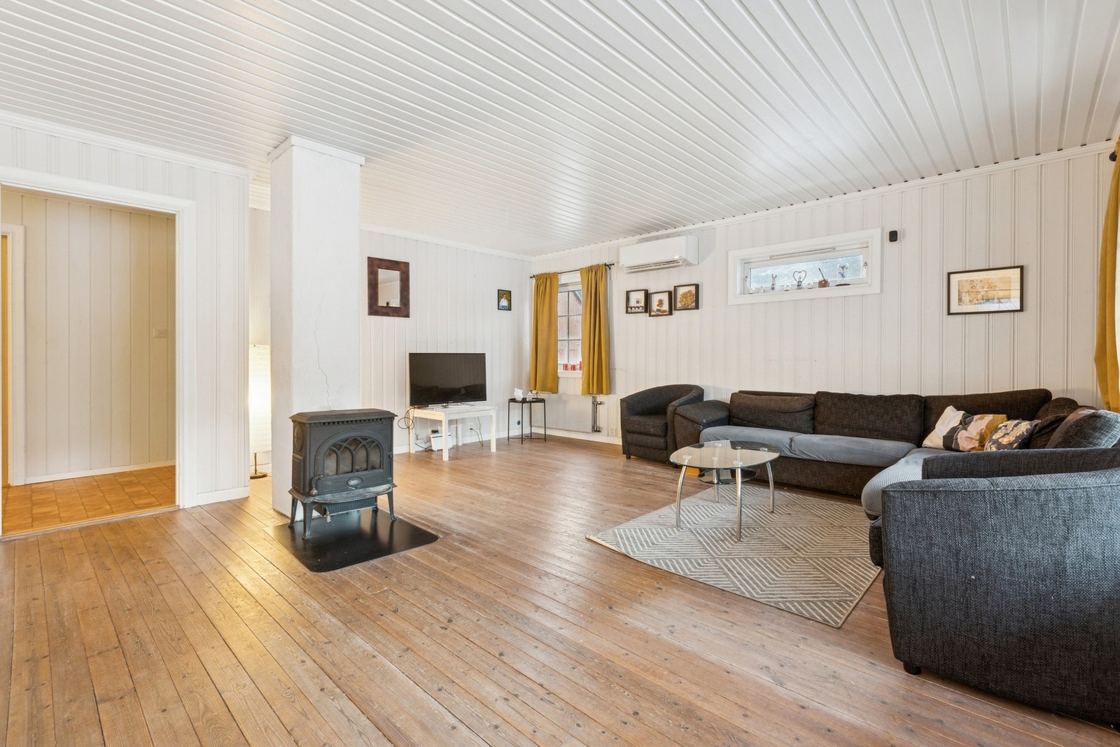 Stue med klassisk tregulv og vedovn. Galleribilde