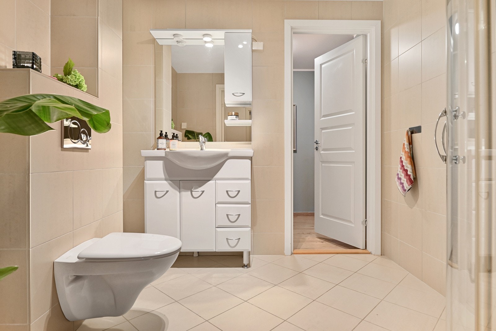 Badet i 1. etasje er innredet med baderomsinnredning, dusjhjørne, vegghengt toalett og opplegg for vaskemaskin. Galleribilde