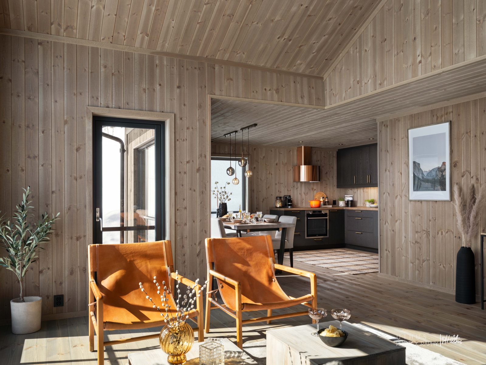 Et sosialt oppholdsrom med åpen stue- og kjøkkenløsning Galleribilde