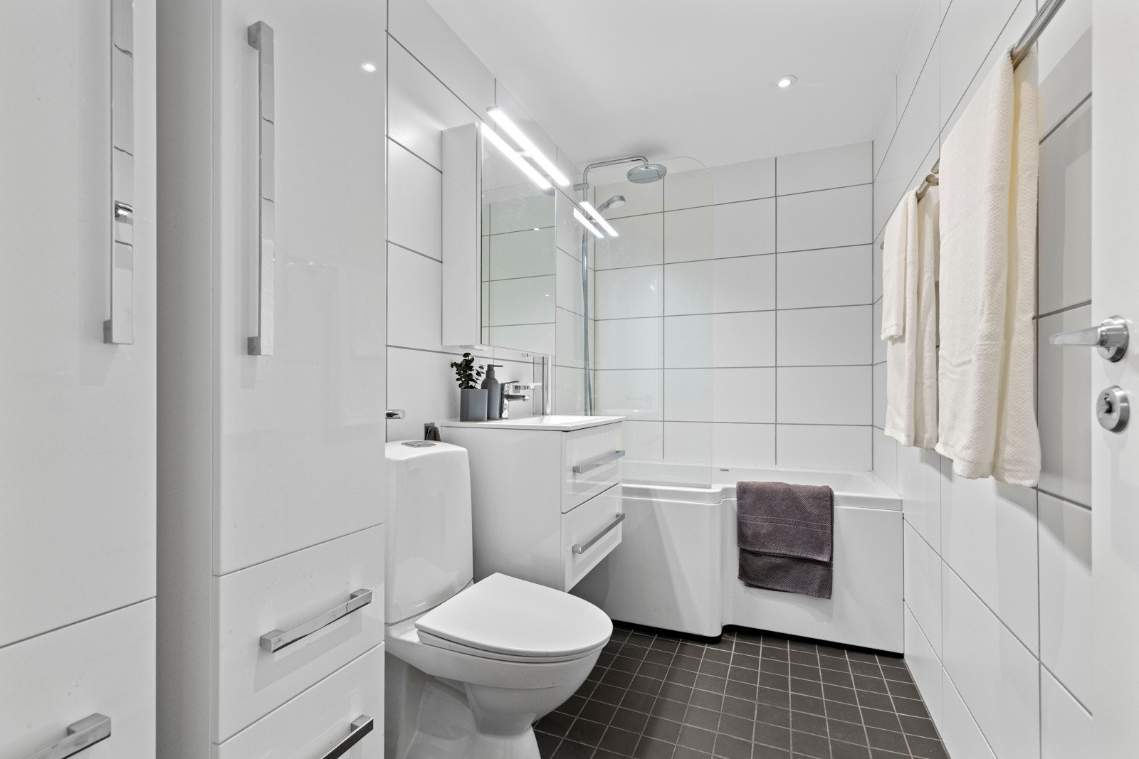 Badet er delikat innredet med lyse fliser, varmekabler i gulv og moderne baderomsinnredning. Galleribilde