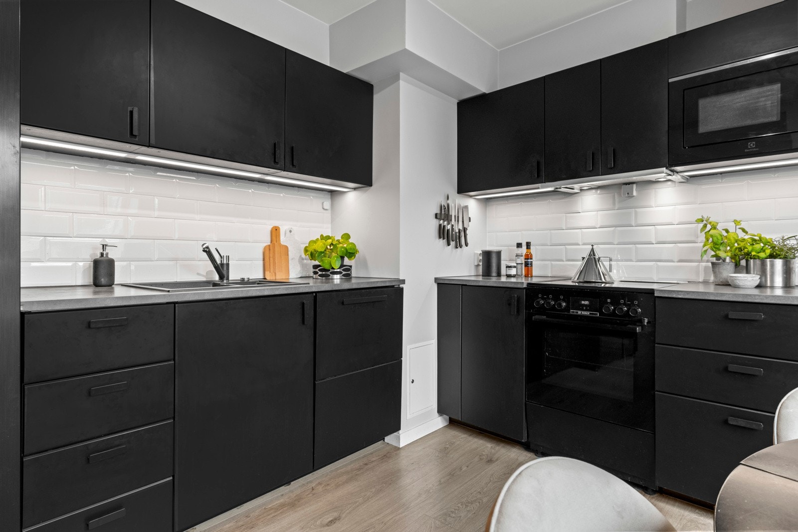 Moderne kjøkkeninnredning med laminat benkeplate og integrerte hvitevarer, kjøl/fryseskap, oppvaskmaskin, komfyr, vaskemaskin, micro. Galleribilde