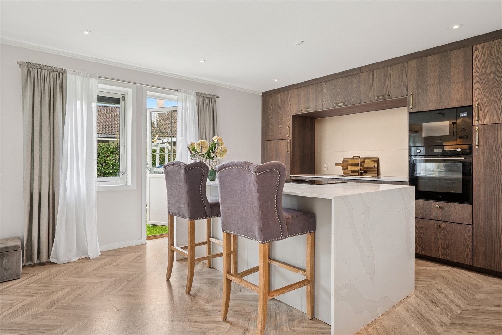 Integrerte hvitevarer som stekeovn, induksjonstopp, mikrobølgeovn, oppvaskmaskin og kjøl/fryseskap. Galleribilde