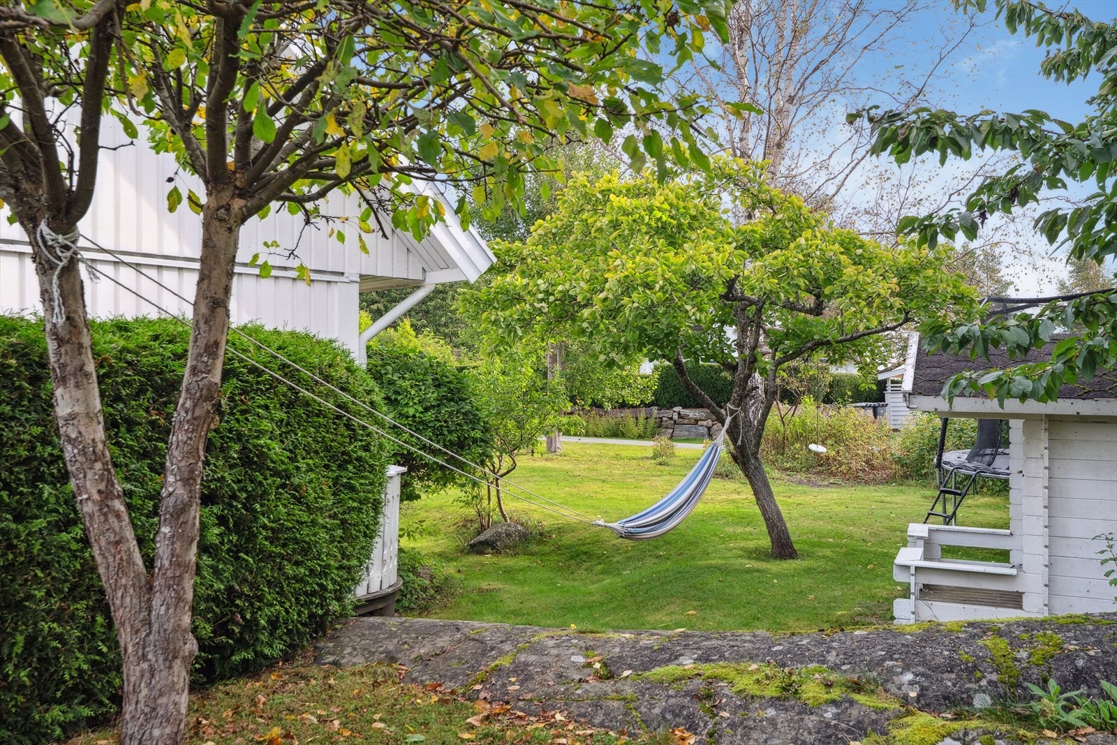 Fra terrassen er det direkte adkomst til den pent opparbeidede hagen med plenarealer, beplantninger, frukttrær og stedvis fjell. Galleribilde