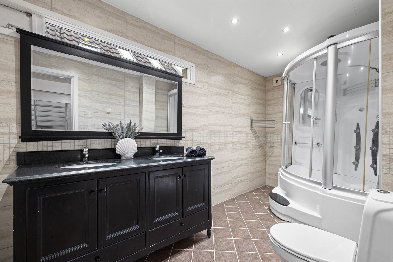 Rommet har innredning med 2 nedfelte servanter, toalett og dusjkabinett/badekar. Galleribilde