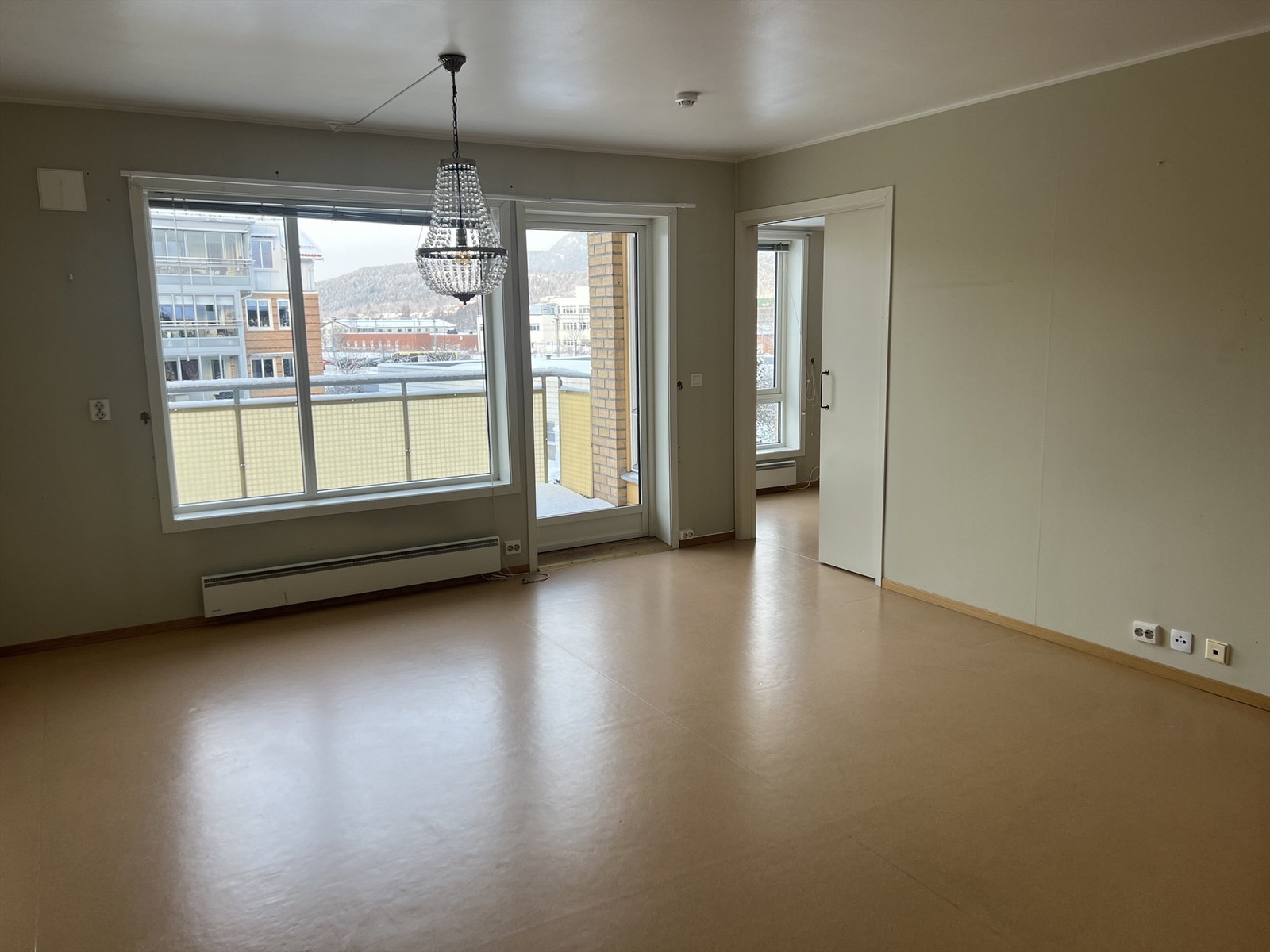 Romslig stue med vinylbelegg på gulv og malte flater på vegger Galleribilde