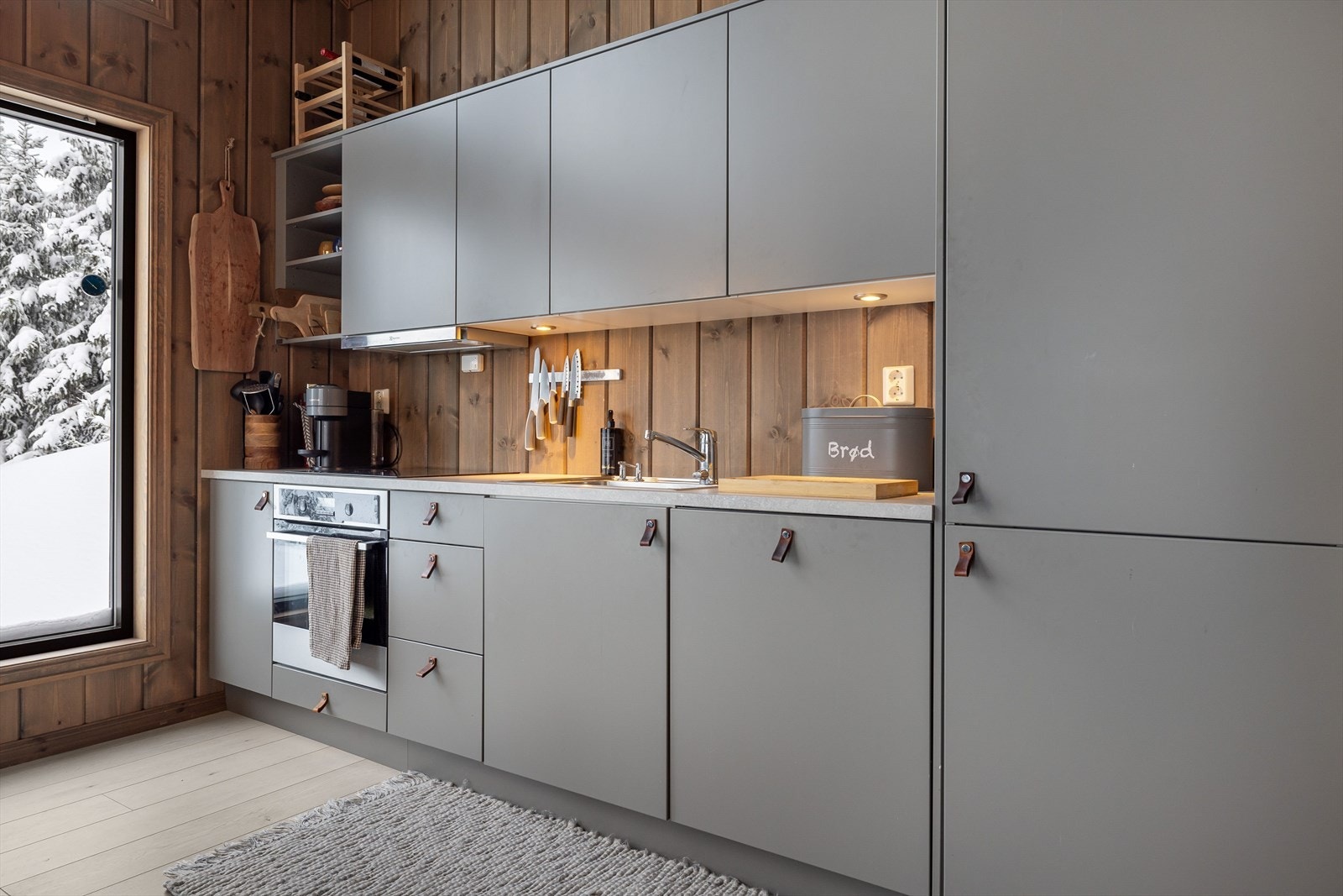 Kjøkkenet har en pen og stilren innredning fra Huseby med grå, glatte fronter. Galleribilde