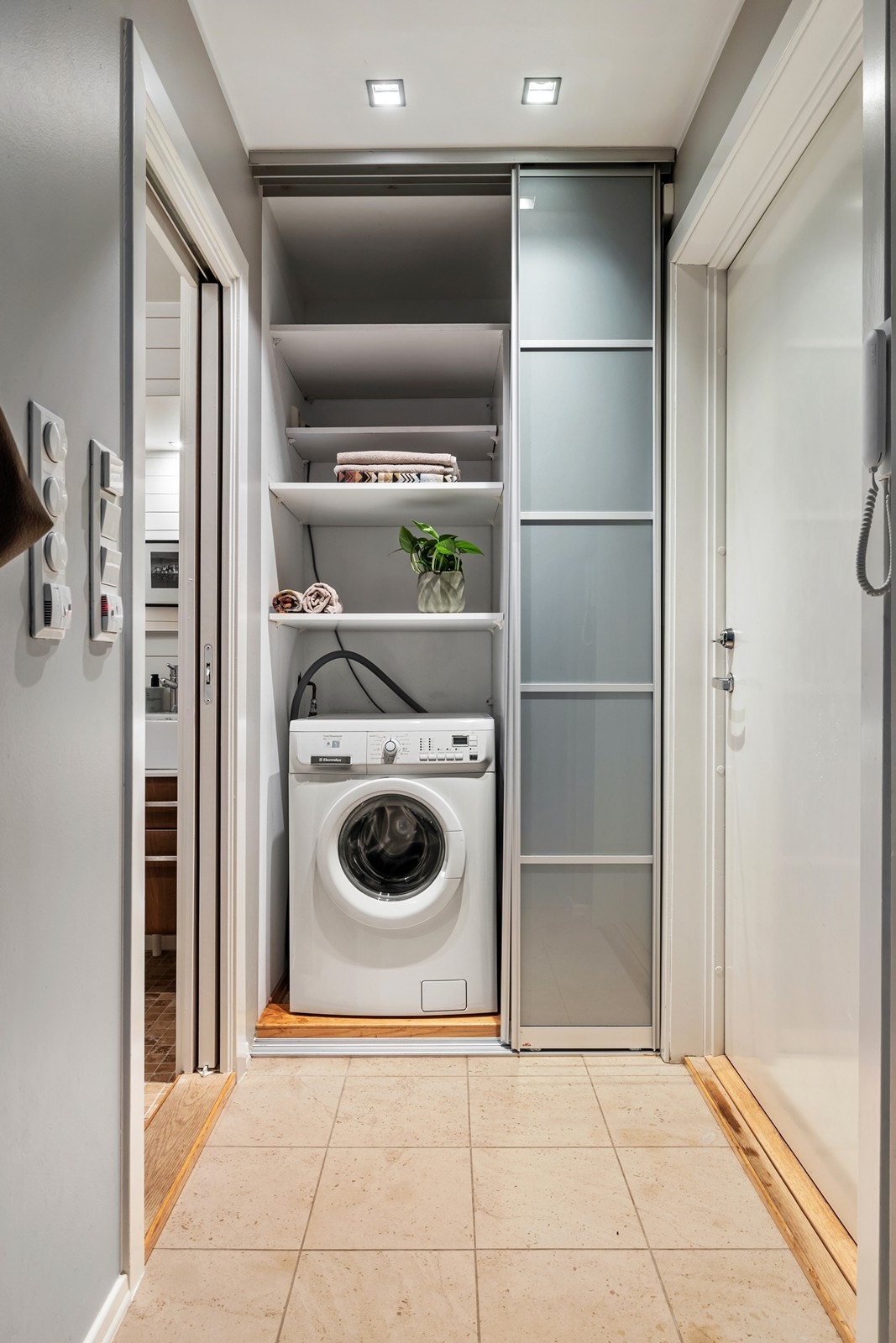 Gang mot garderobe. Smart løsning med vaskemaskin (medfølger) og skyvedør til badet Galleribilde