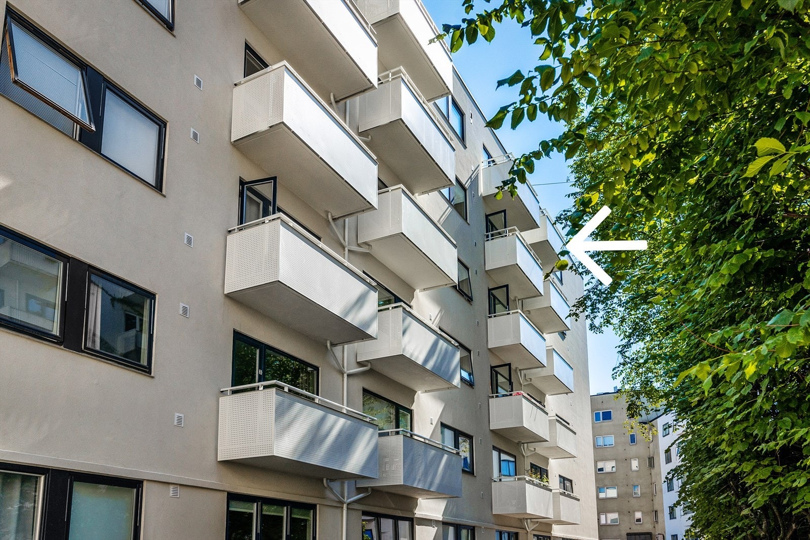 Bilde av fasade tatt sommerstid markert med boligens plassering. Høyt og fritt i 6. etasje (toppetasjen) Galleribilde