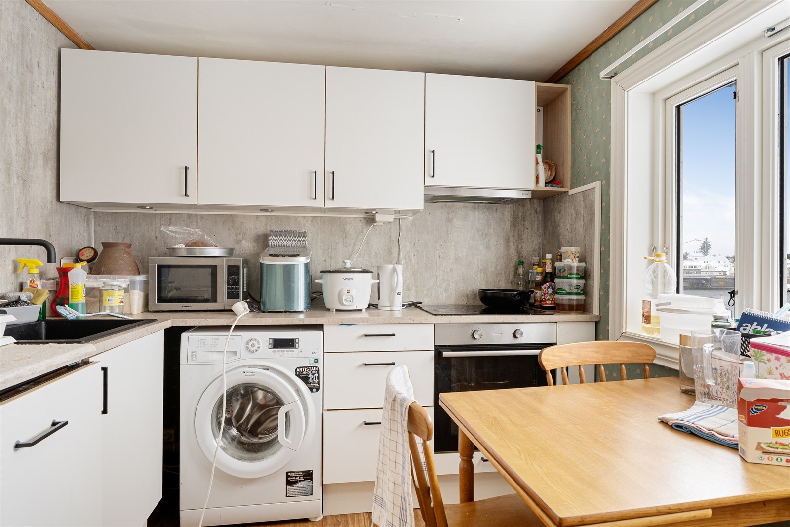 Kjøkkenet har integrert platetopp, stekeovn og oppvaskmaskin samt frittstående kjøl/fryseskap - det er også opplegg for vaskemaskin Galleribilde