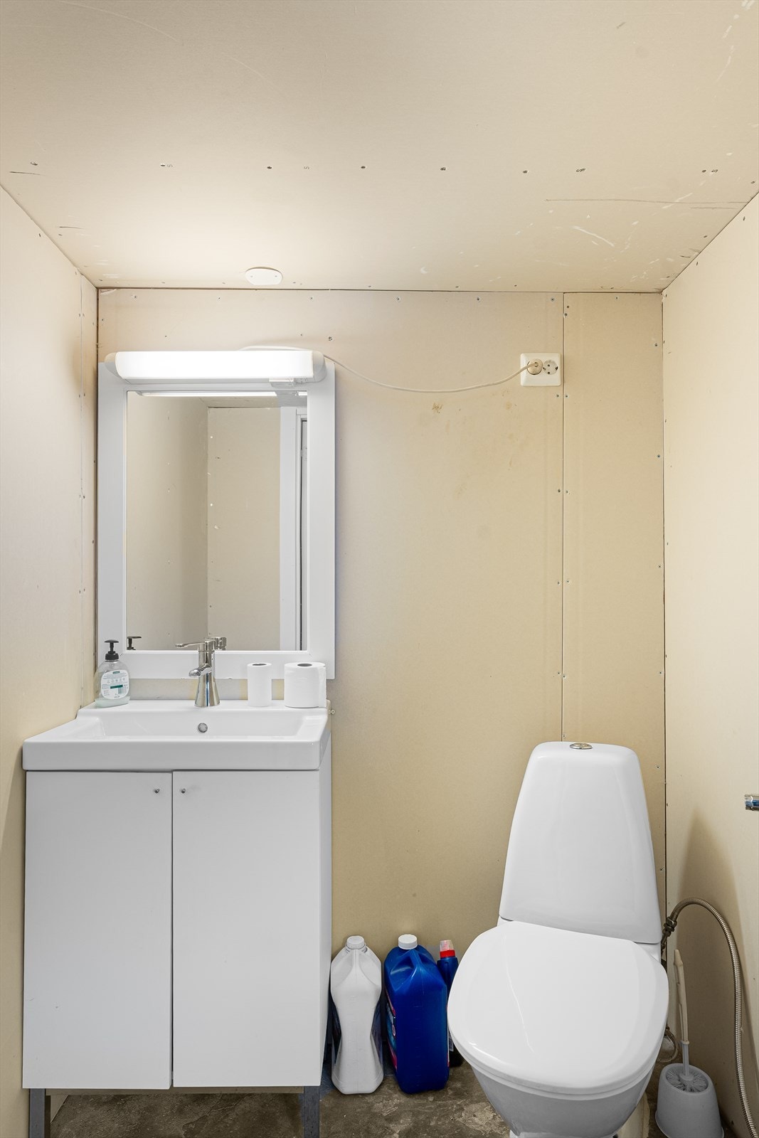 Toalettrom i kjelleren med betonggulv samt ubehandlet gips på vegger og himling Galleribilde