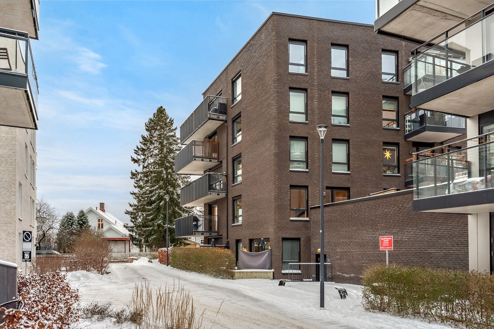 Bygningen har en fasade med teglstein og flere balkonger, noe som gir et stilrent uttrykk. Galleribilde