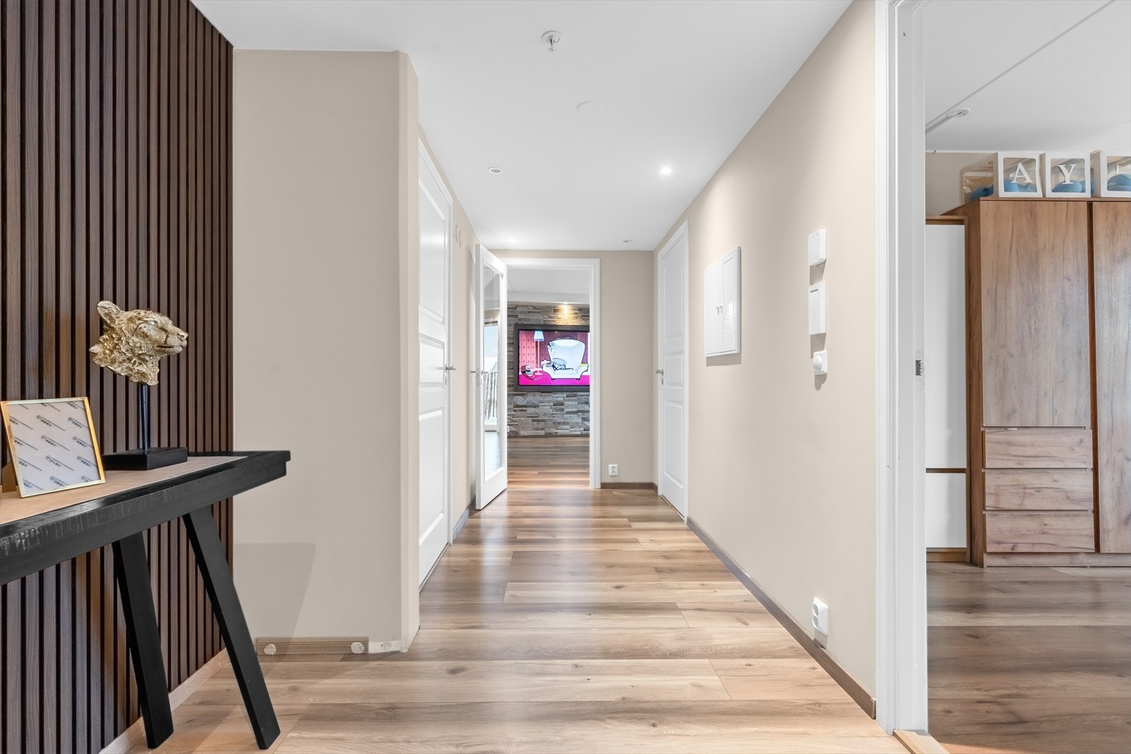 Laminatgulvet fra 2023 gir et moderne preg til gangen, som har malte vegger og profilerte dører. Galleribilde