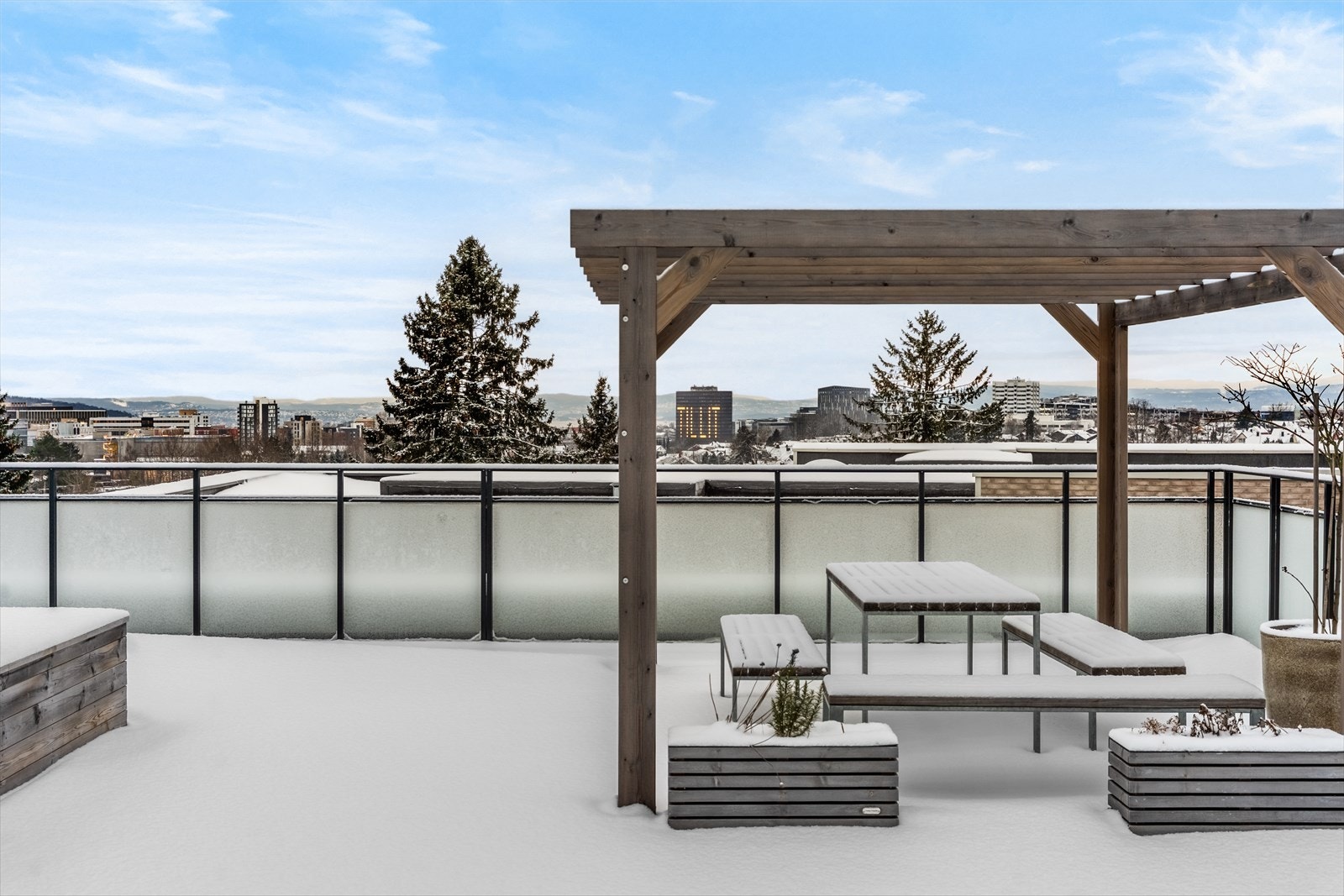 Takterrassen har en pergola og sittegruppe, med utsikt over byen og omkringliggende grøntområder. Galleribilde