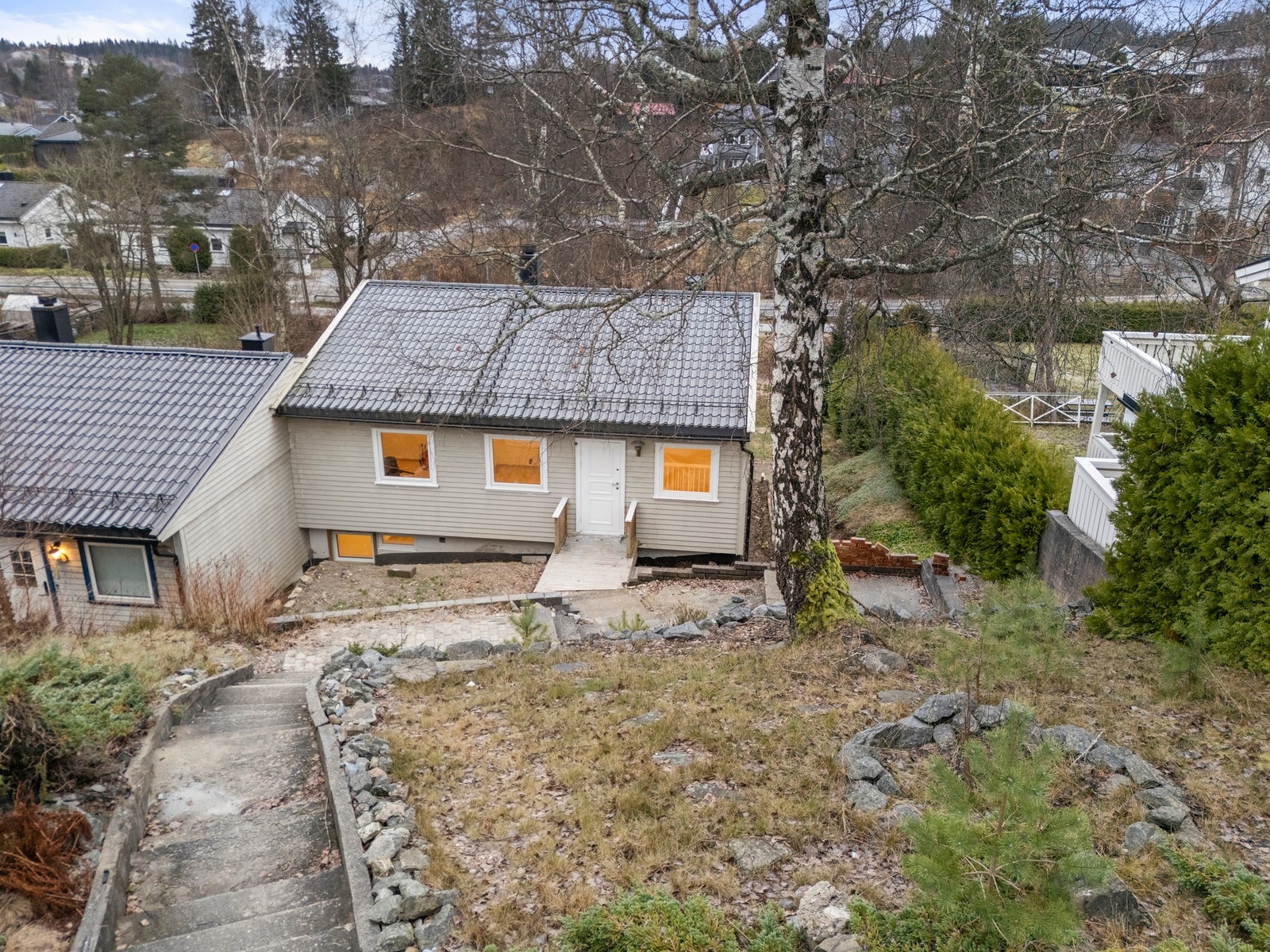 Det er etablert støpt betongtrapp og støttemur som bidrar til en funksjonell og tilrettelagt tomt. Galleribilde