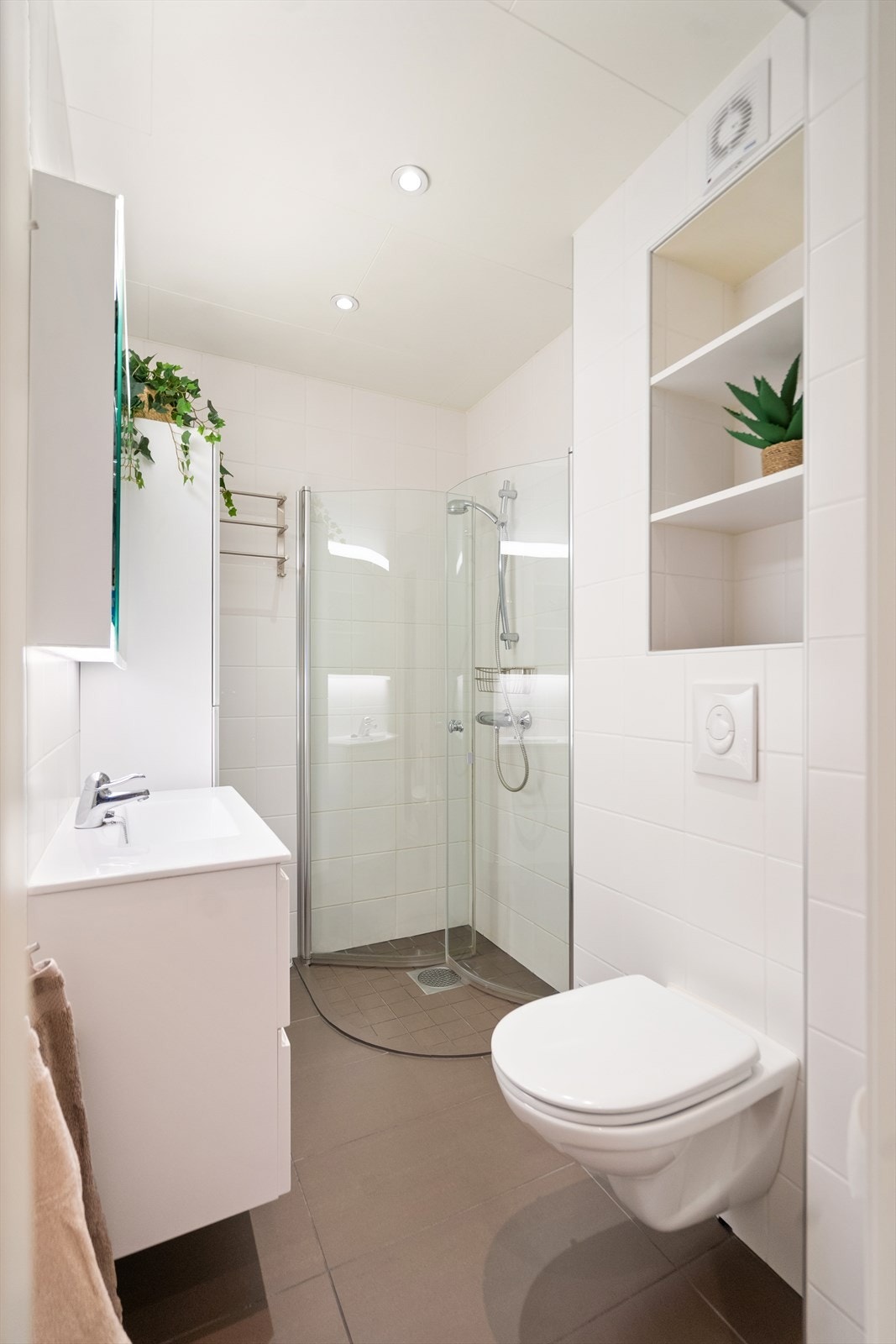 Pent flislagt bad med dusjhjørne med innfellbare slagdører. Galleribilde