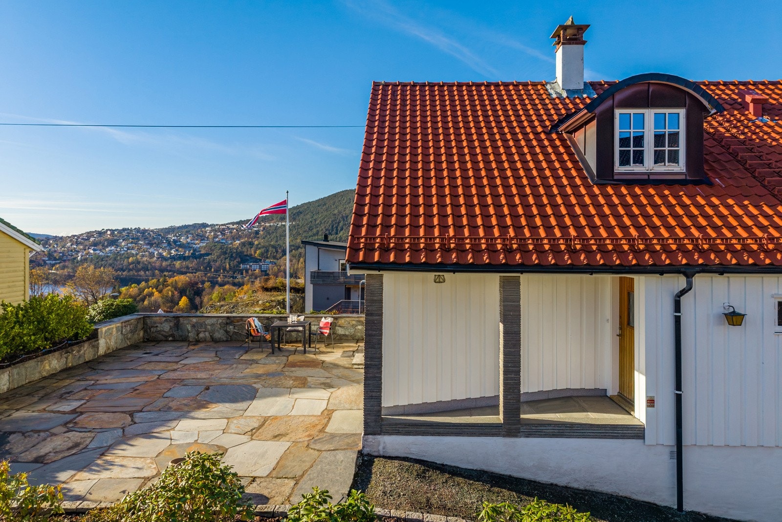 Innbydende skiferlagt uteplass. Trappefri adkomst med overbygd inngangsparti. Galleribilde