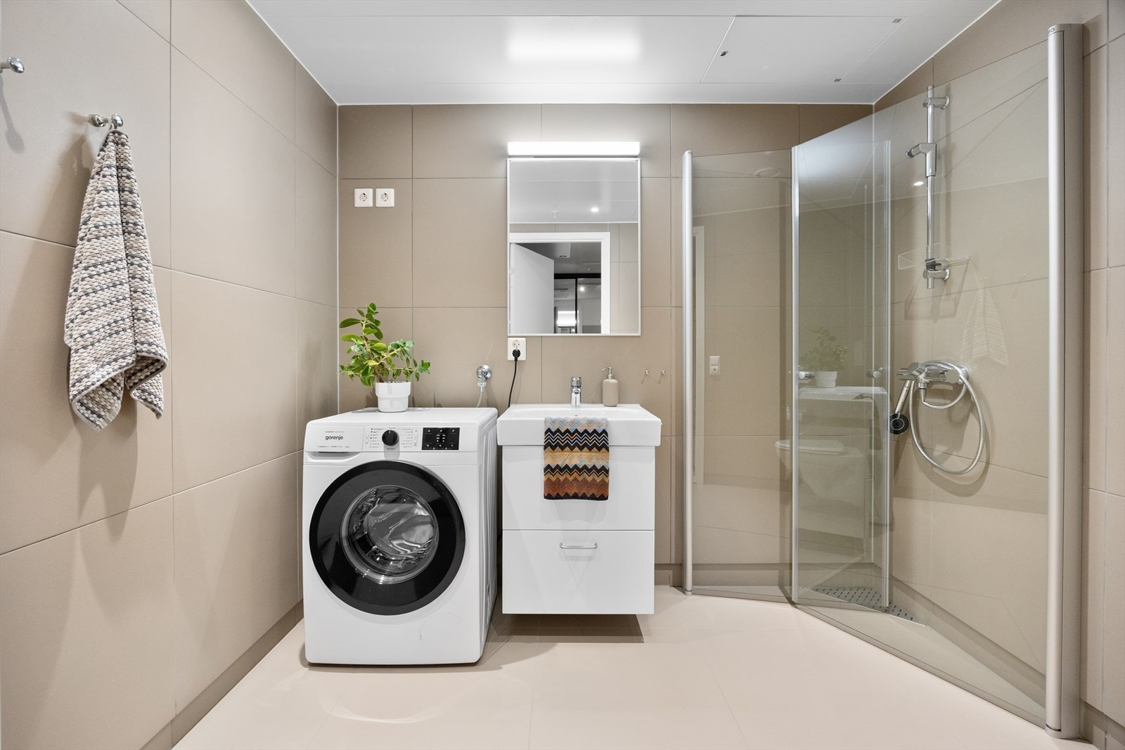 Badet er i delikate fargetoner og har plassbesparende løsninger. Galleribilde