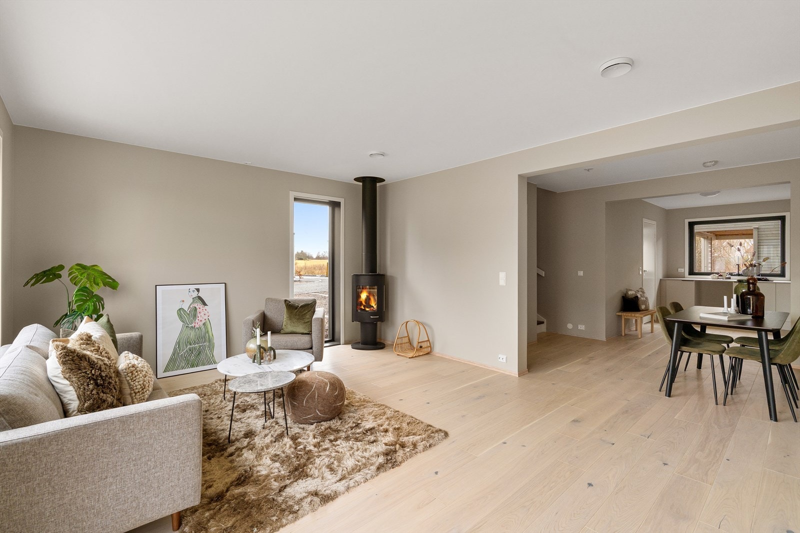 Moderne og lys bolig med åpen planløsning, peisovn og store vinduer som slipper inn rikelig med naturlig lys. Galleribilde