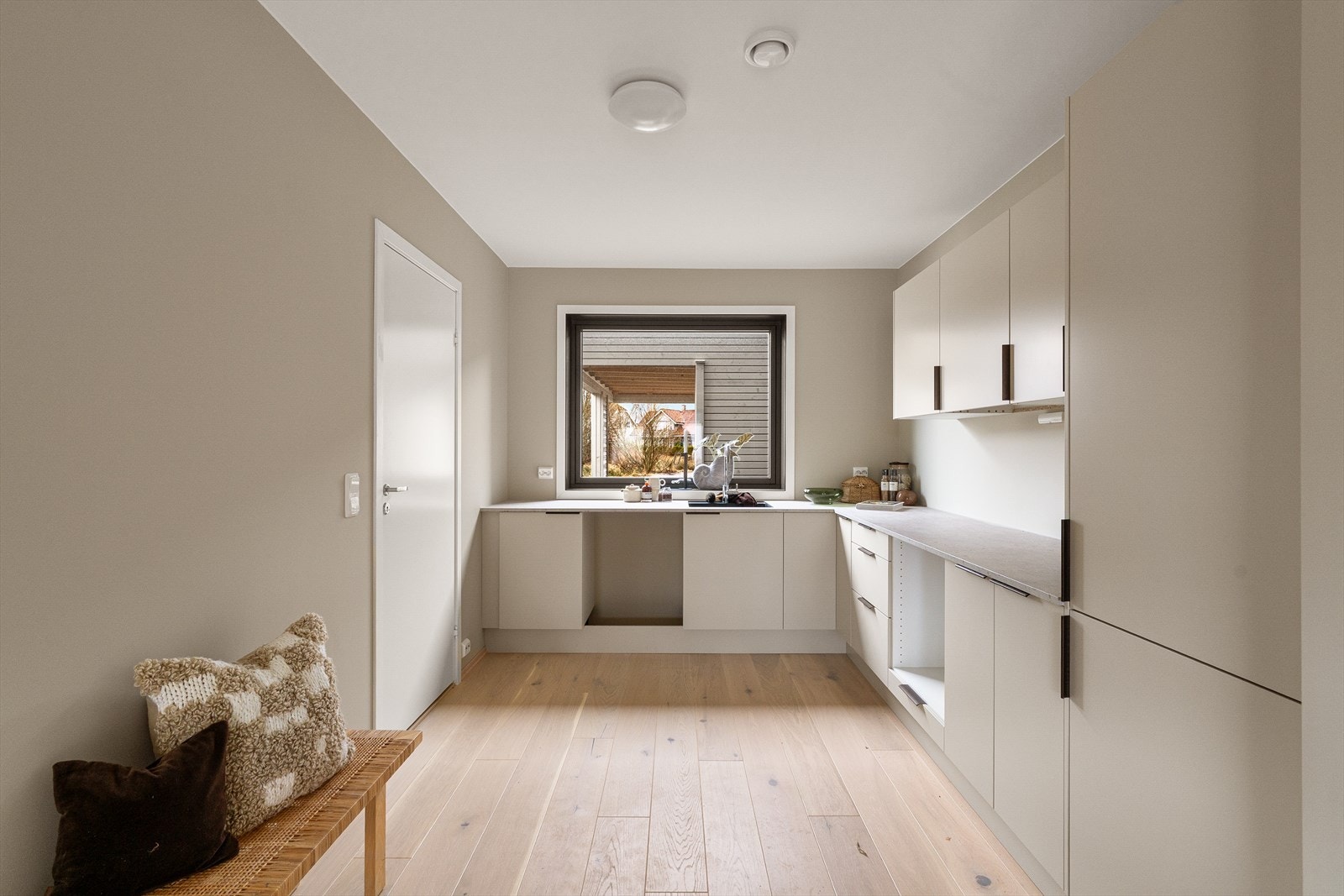 Lys og moderne kjøkkenløsning med god plassutnyttelse. Store vinduer gir rikelig med naturlig lysinnslipp. Galleribilde