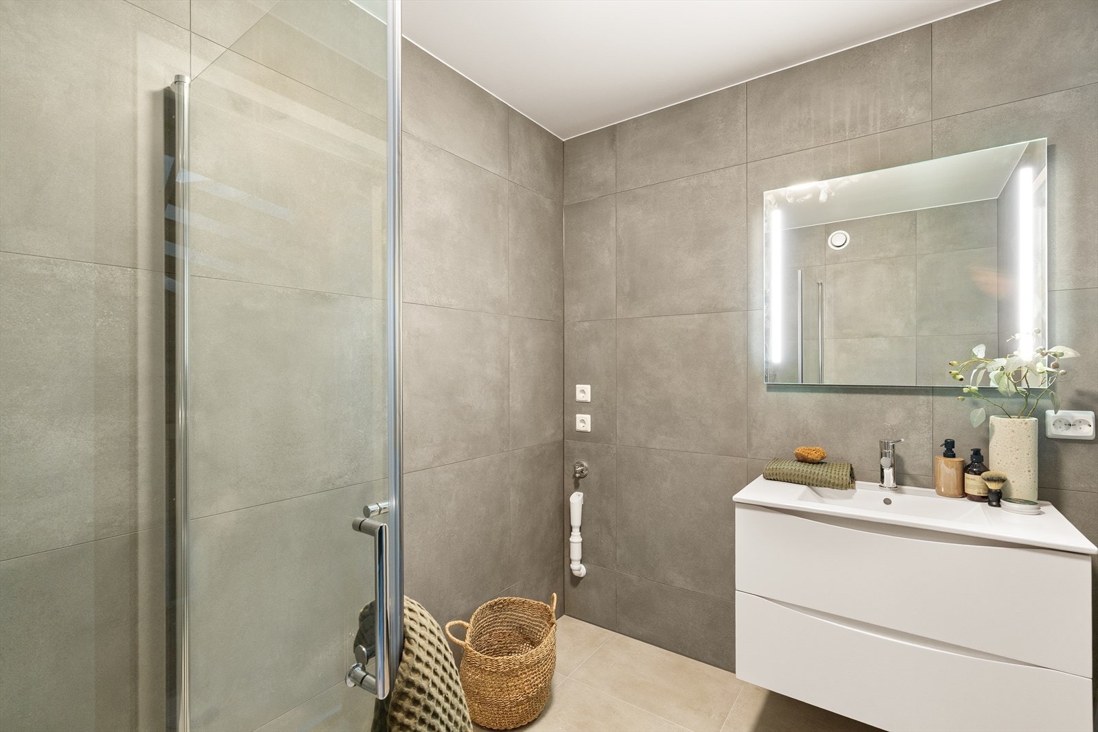 Moderne bad med stilrene fliser og elegant belysning, gir en følelse av luksus og komfort i hjemmet. Galleribilde