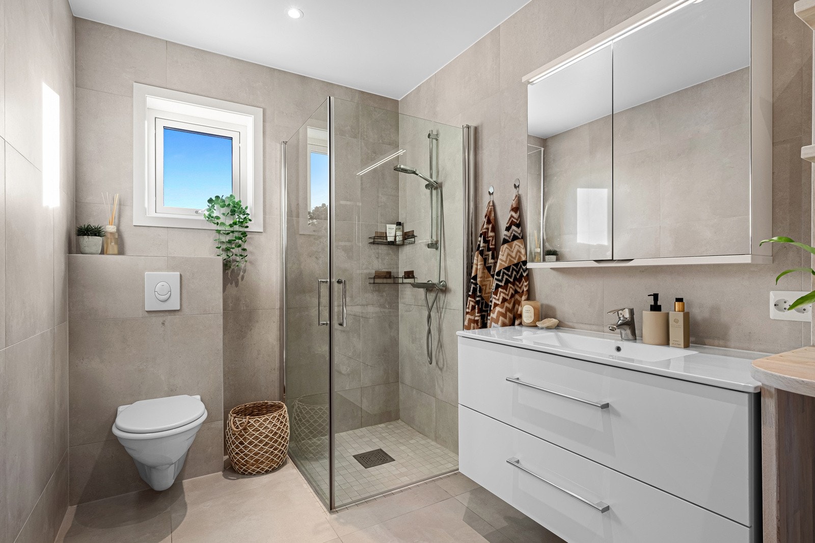 Leilighets bad er lekkert flislagt i lyse fargetoner. Galleribilde