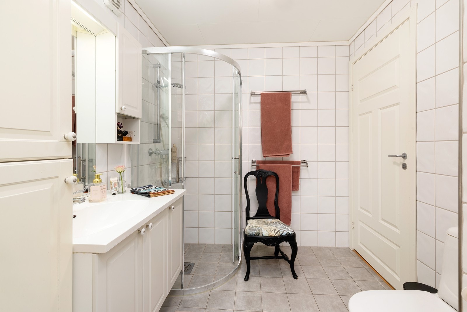 Flislagt bad, innredet med toalett, dusj, heldekkende servant med underskap, speil og overskap. Det er varmekabler i gulv. Galleribilde