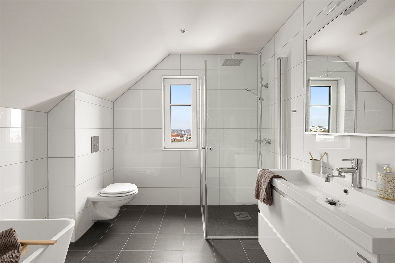 Lyst og moderne bad med rene linjer, stilren dusj og elegant flislagt vegg. Galleribilde