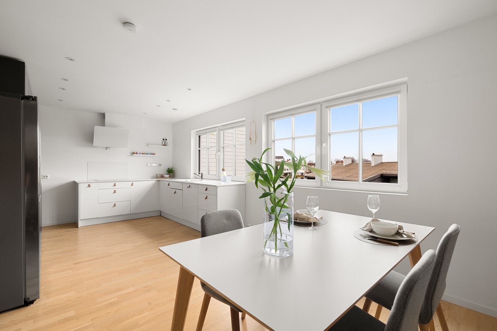 Lys og moderne kjøkkenløsning med romslig spiseplass og flotte vinduer som gir rikelig med naturlig lys. Galleribilde