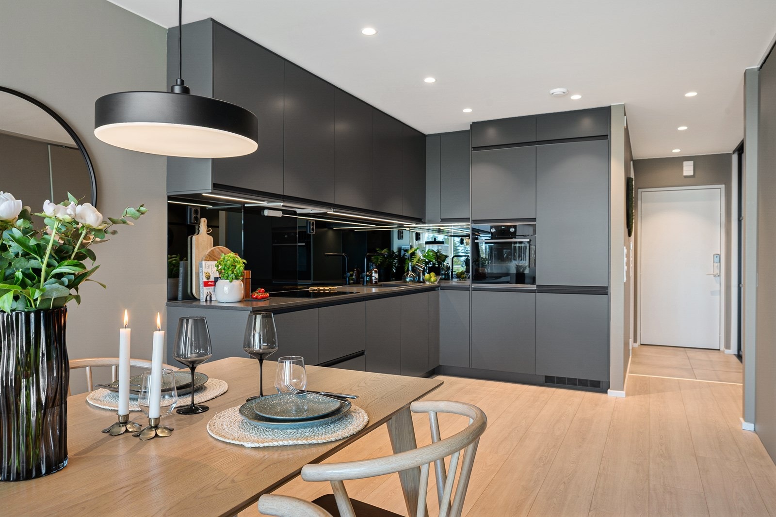 Kjøkkeninnredningen har mørke, slette fronter og laminat benkeplate. Galleribilde