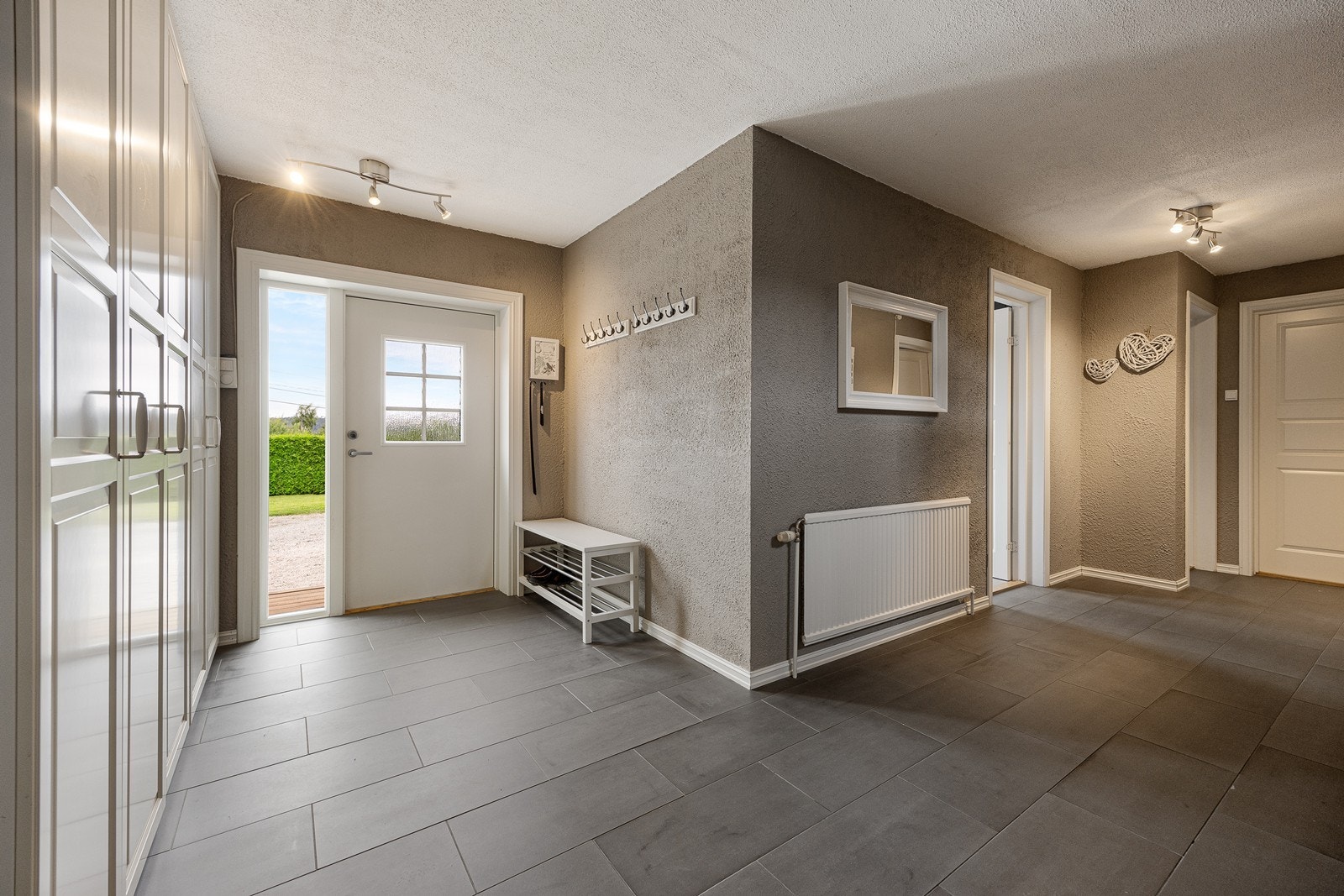 Hallen har god gulvplass og gir adkomst til hele etasjen samt trappeløpet opp til hovedetasjen. Galleribilde