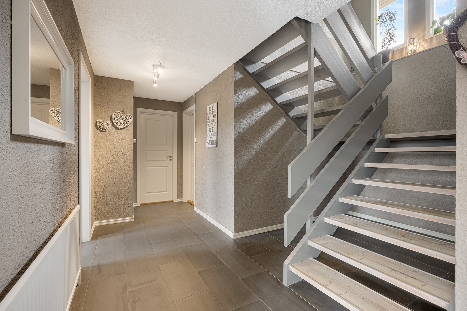 Fra hallen i underetasjen er det en bred og åpen trapp opp til hovedetasjen. Trapperommet får fint lysinnfall fra to vinduer i yttervegg. Galleribilde