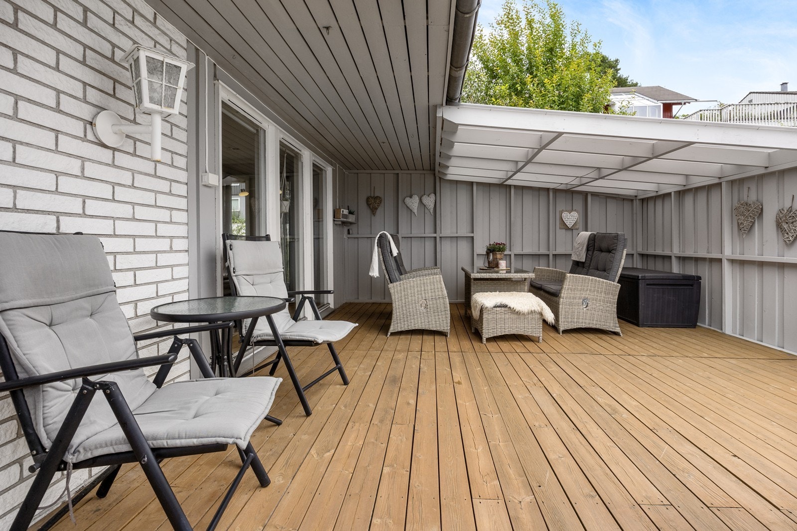 Terrassen har dekke i tre, tette levegger og klassisk utebelysning. Galleribilde