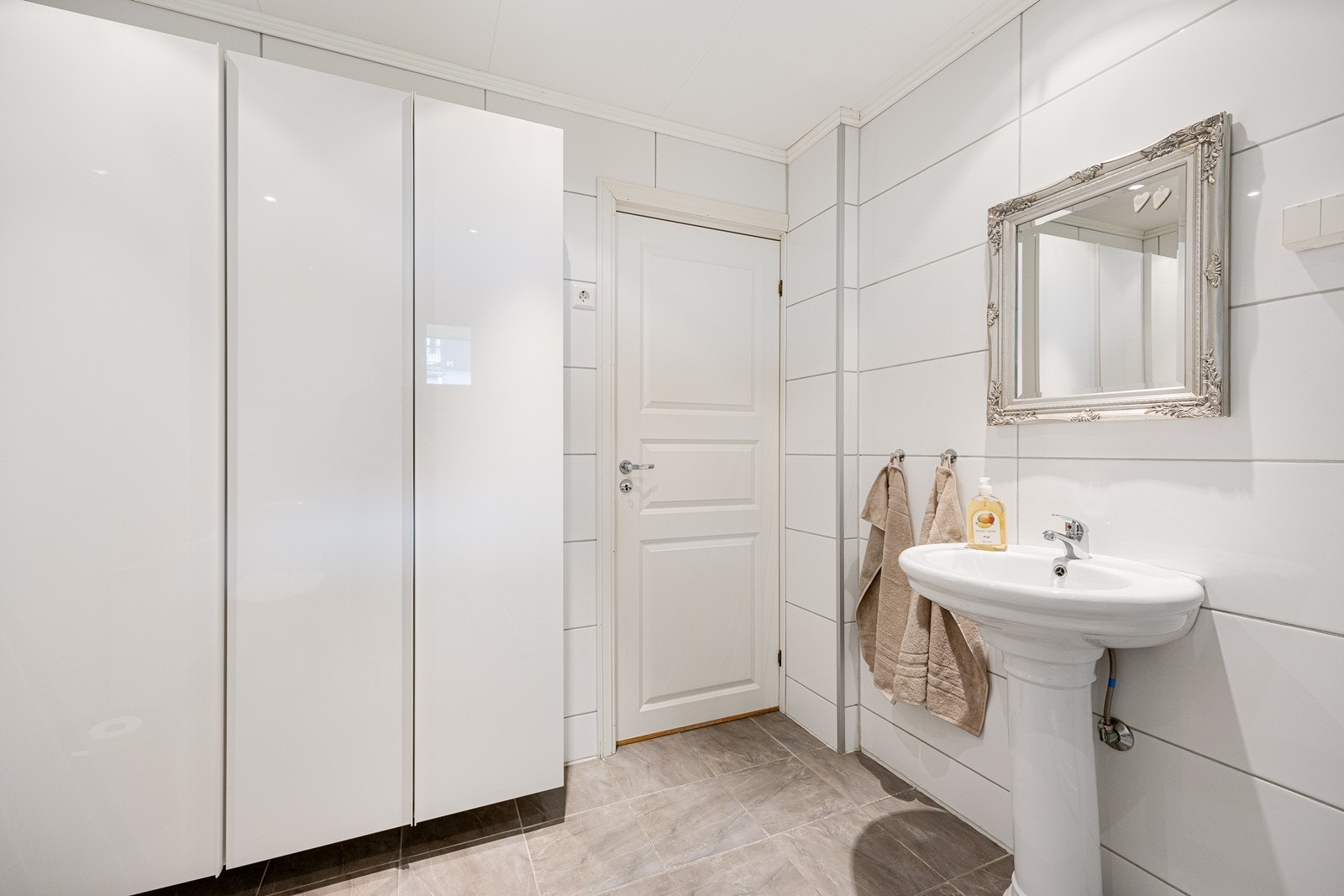 Av innredning er det en søyleservant, og badet er videre utstyrt med en radiator, mekanisk avtrekk, et toalett og et dusjkabinett. Galleribilde