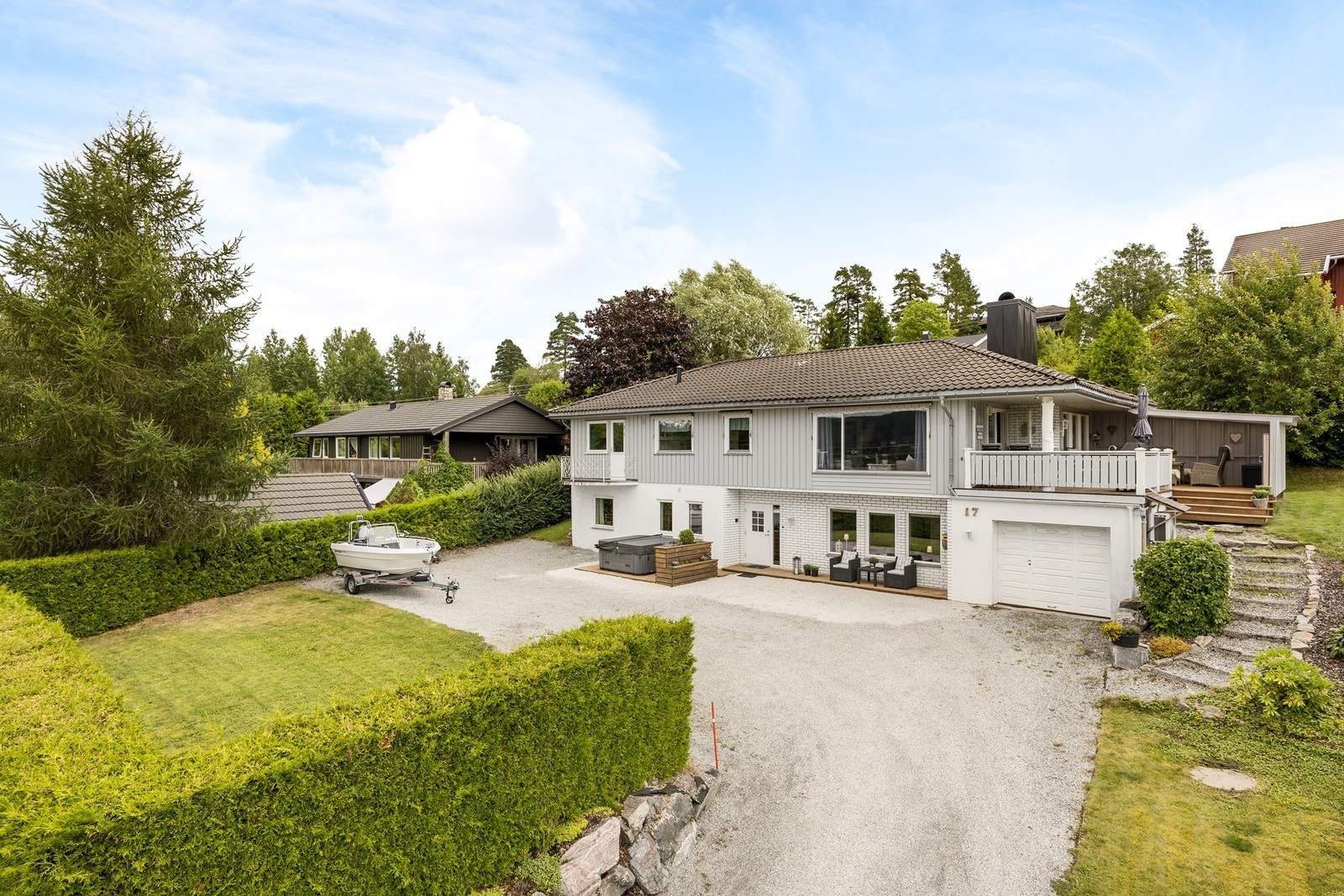 Tomten er skrånende, vestvendt og meget pent opparbeidet med gressplen, trær, gruslagt gårdsplass og tett, velfrisert hekk. Galleribilde