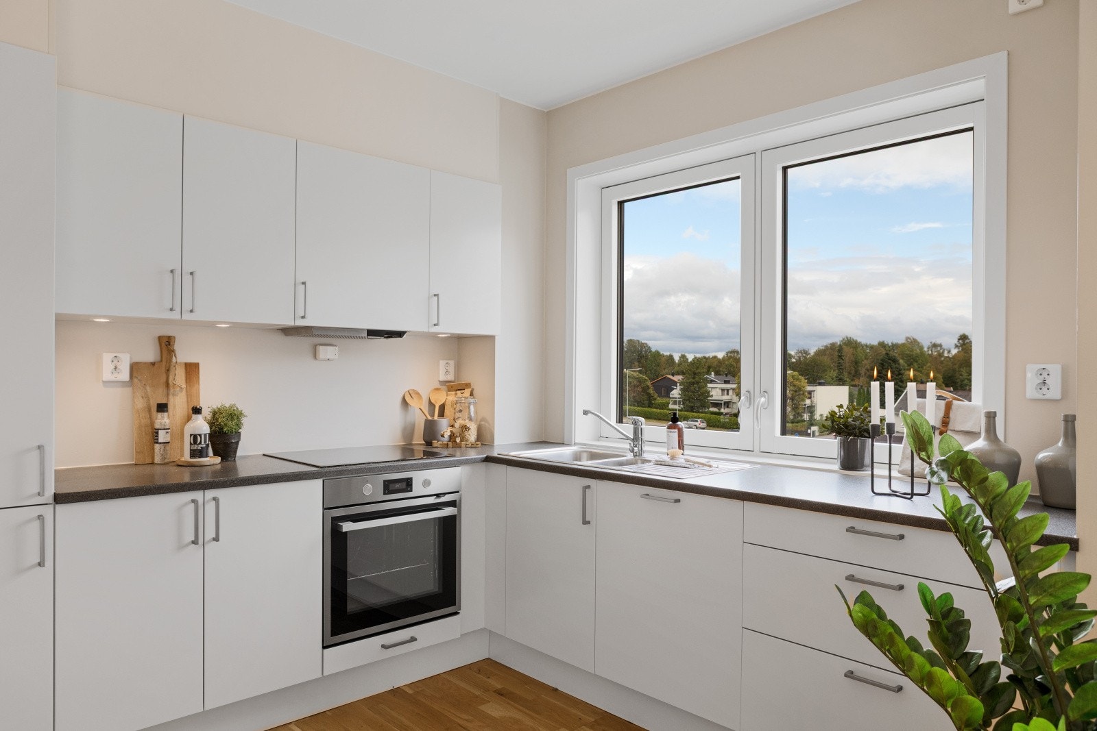 Klassisk, tidløs kjøkkeninnrednig med tilhørende hvitevarer som komfyr, koketopp, oppvaskmaskin og kombinert kjøl/frys. Galleribilde