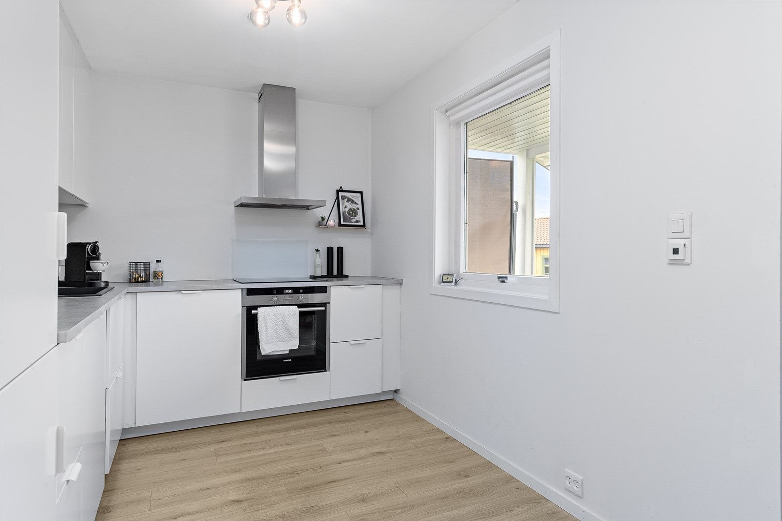 Klassisk kjøkkeninnredning med hvite slette fronter og benkeplate av laminat. Galleribilde