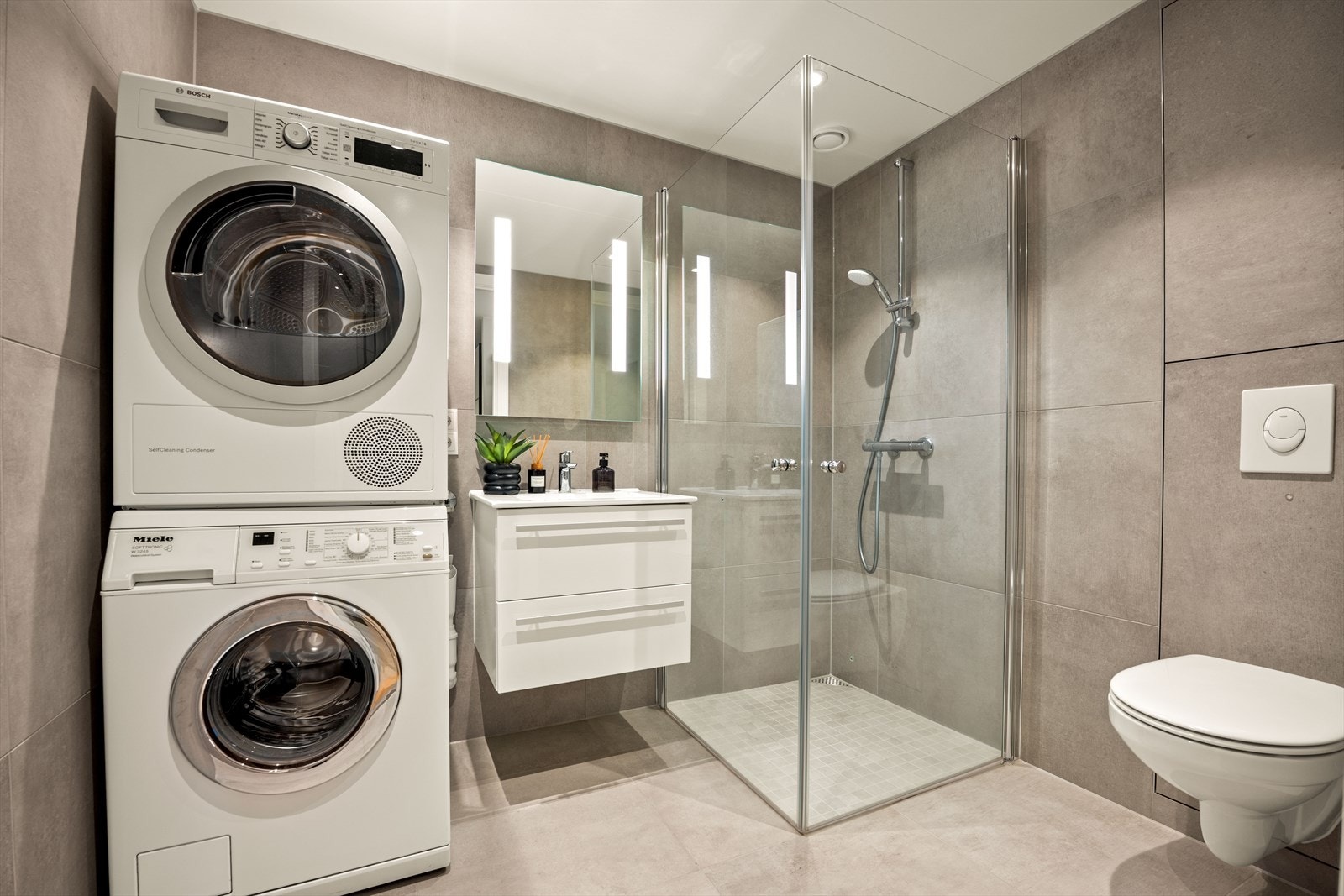 Baderom nr 2 er romslig og har også pen stil med fliser i stort format Galleribilde