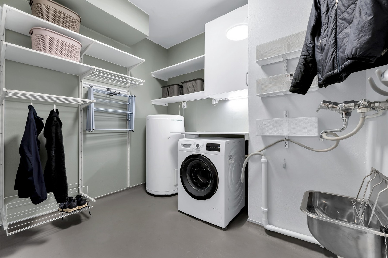 Leiligheten har også et stort og praktisk vaskerom med mye oppheng for klesvask. Ellers mye praktisk hylleplass for lagring. Galleribilde