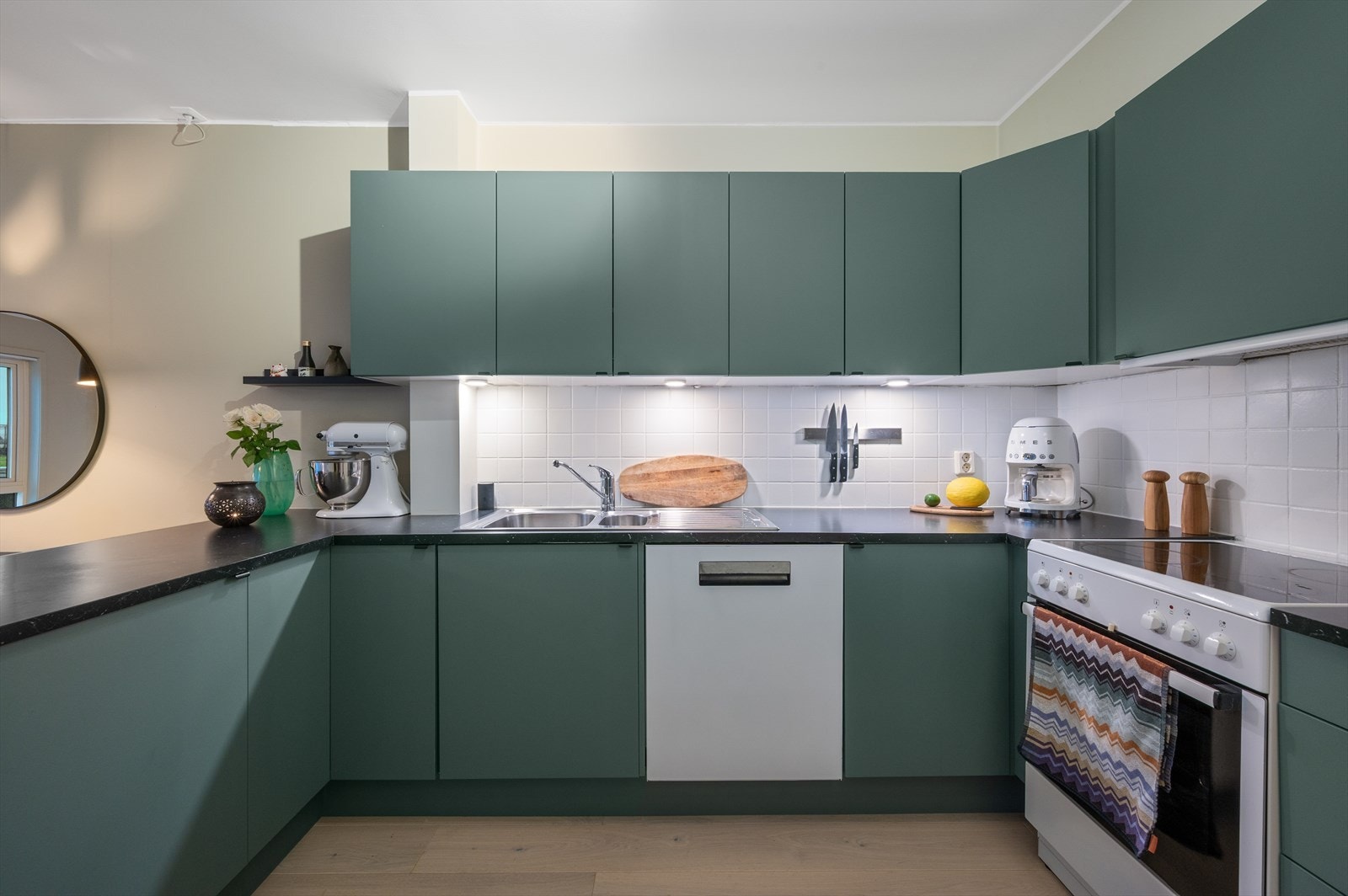 Det er videre fliselagt mellom benkeplate og overskap, opplegg for oppvaskmaskin, samt kjøkkenventilator med mekanisk avtrekk. Galleribilde