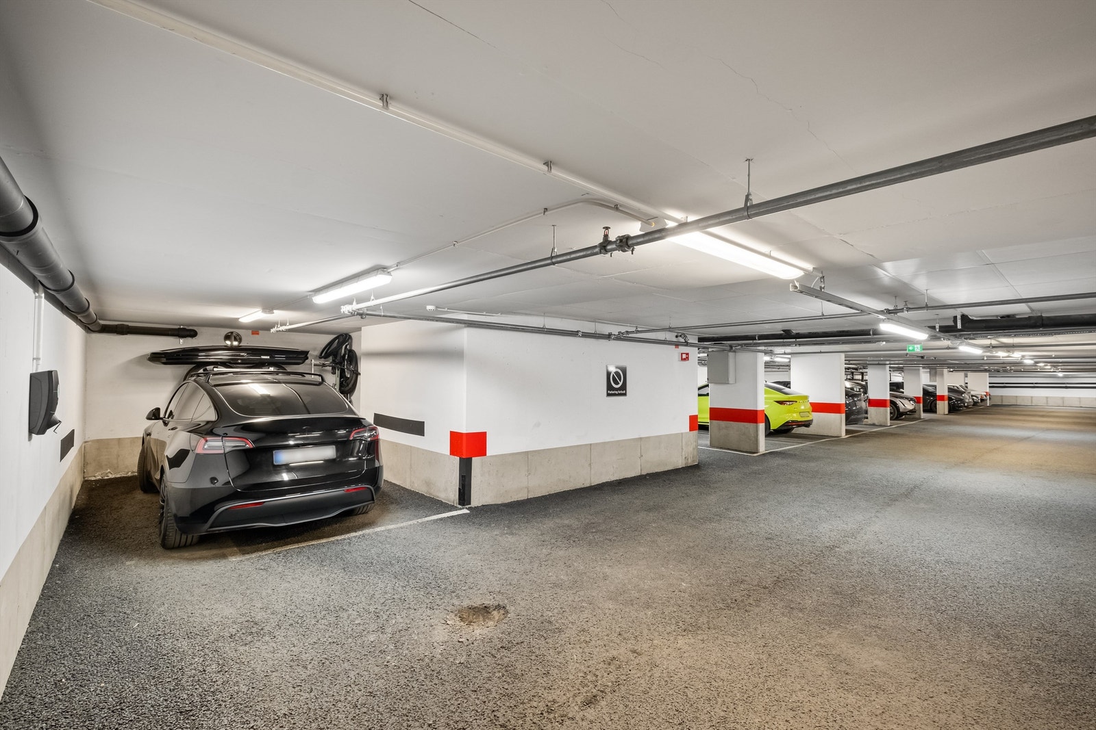 Romslig garasjeplass med el-lader og to dekkstativ som medfølger. Galleribilde