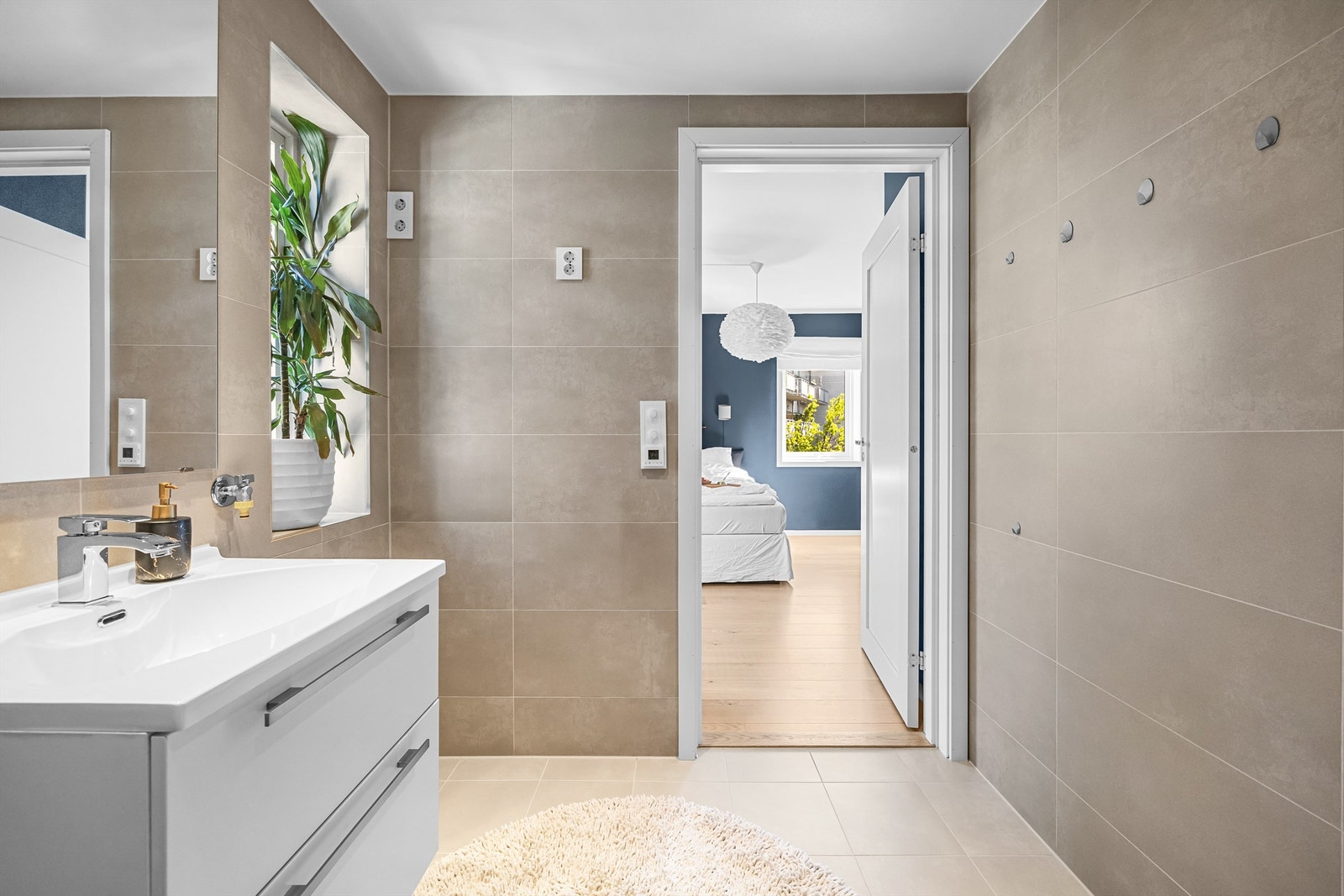 Hovedsoverommet er tilknyttet et eget bad. Stilrent og pent flislagt med varmekabler i gulv. Galleribilde