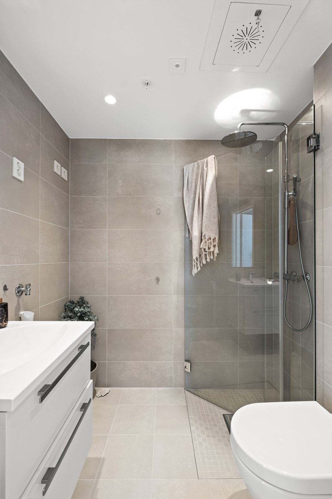 På bad nummer to finner du også et dusjhjørne med regnfallsdusj og glassdører, vegghengt klosett, og servant nedfelt i innredning med skuffer. Det er også opplegg for vaskemaskin her. Galleribilde