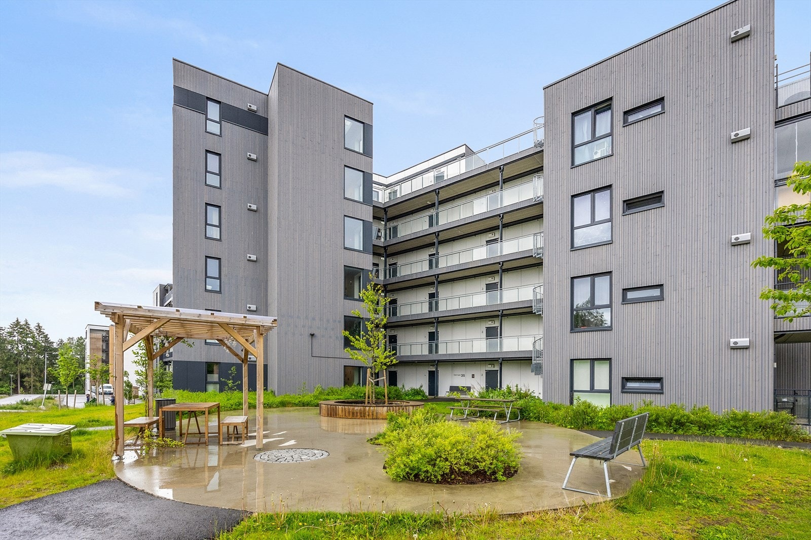 Pergola og sittegruppe i fellesarealet innbyr til hyggelige stunder utendørs. Galleribilde
