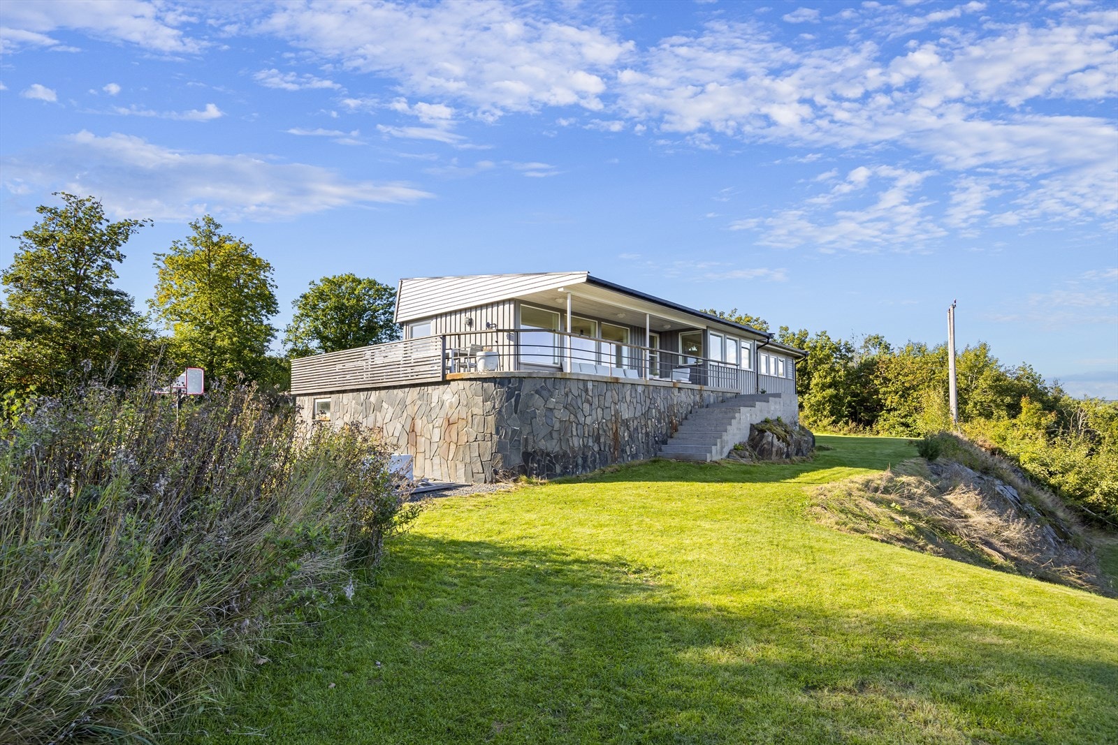 Rundt bebyggelsen er det flott hageanlegg med plen rundt bebyggelsen, gangvei og nivåer, trapp til brygge og terrasse på flere sider inkludert stor solterrasse mot sydvest ved inngangsparti. I tillegg er det syd- og østvendt utsiktsterrasse mot sjøsiden. Galleribilde
