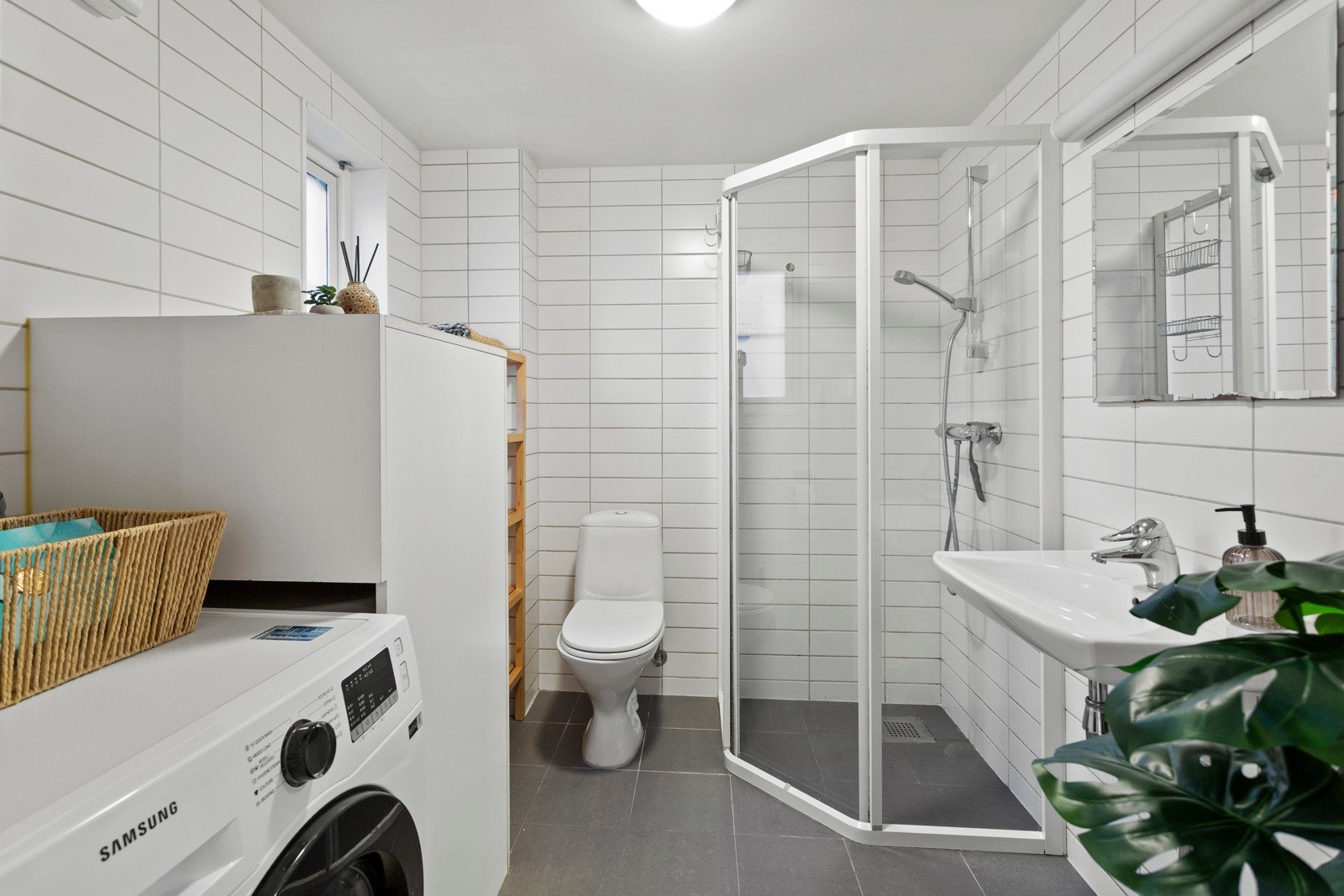 Badet er helfliset med varmekabler i gulvet og holder en gjennomført standard. Her finner du toalett, servant, dusjhjørne og opplegg for vaskemaskin. Galleribilde