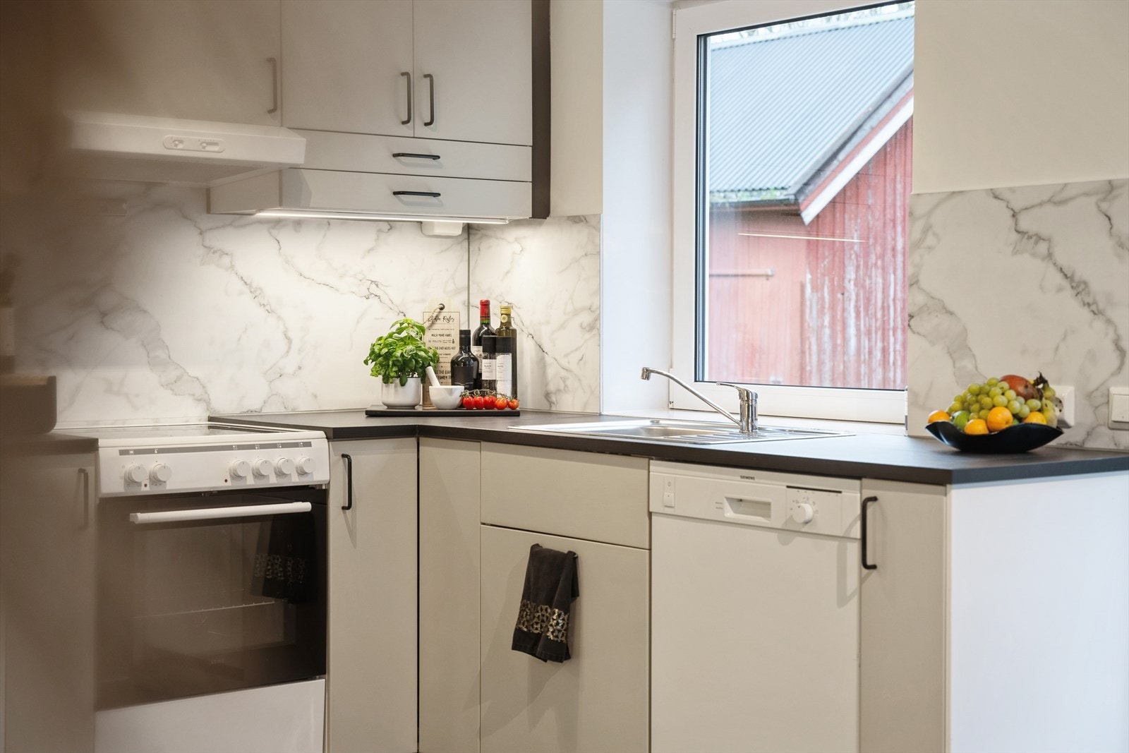 Stilrent kjøkken i 1. etasje fra 2020 med innredning av glatte fronter og benkeplate av laminat. Galleribilde