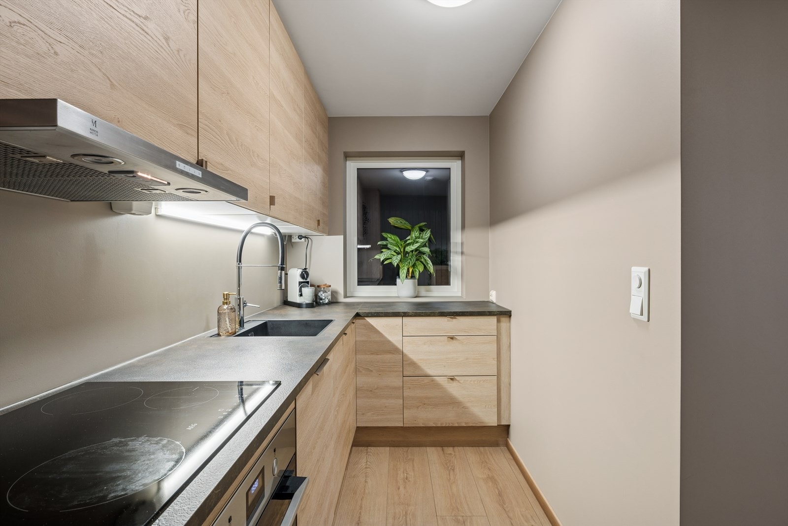 Kjøkkenet ligger praktisk plassert med kort vei til boligens stue/spisestue. Rommet er smart utnyttet i en L-kjøkkenløsning som gir god arbeidsflyt og effektiv bruk av plassen. Galleribilde