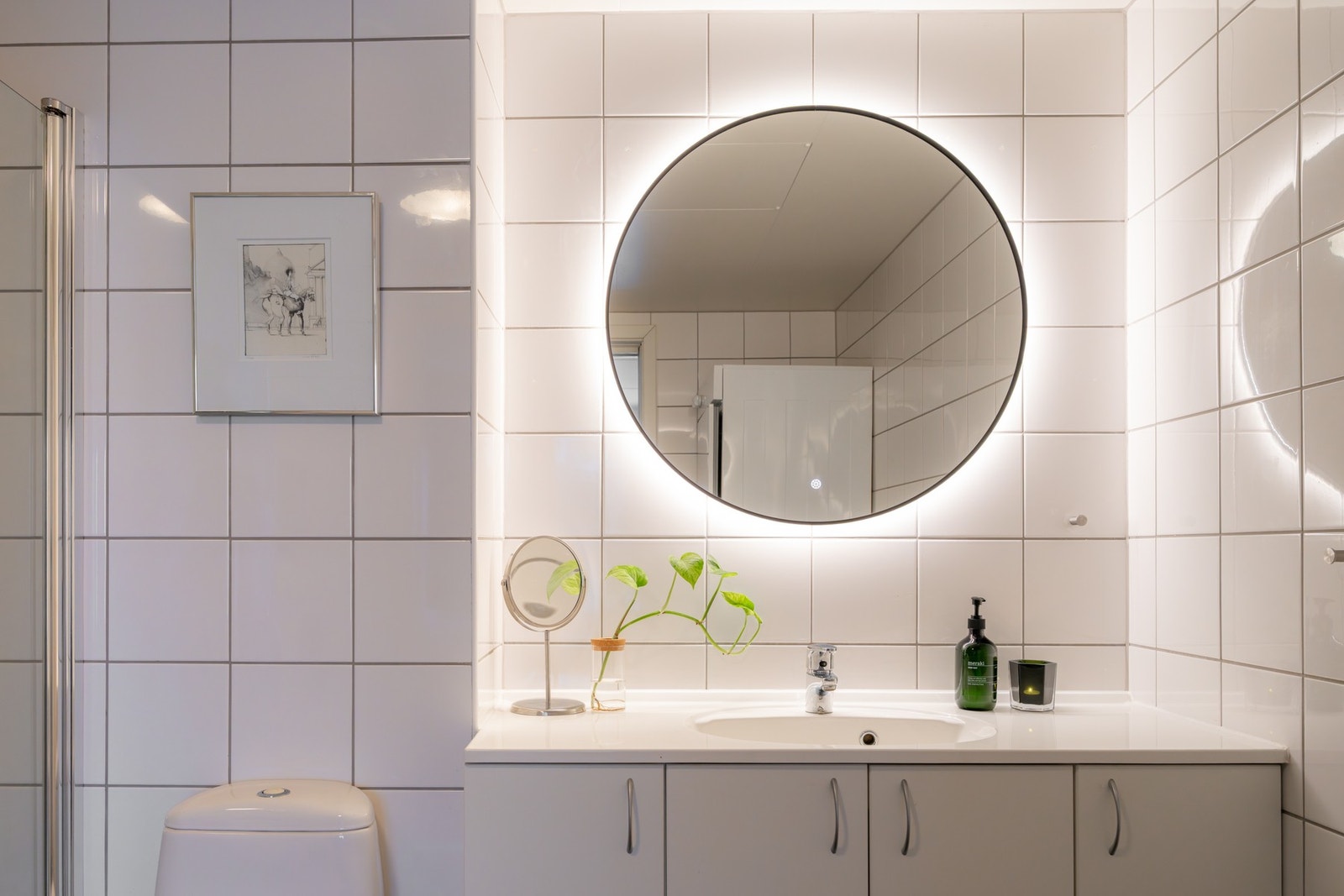 Innredningen består av servant på underskap, speil med integrert belysning og vegghengt toalett. Galleribilde