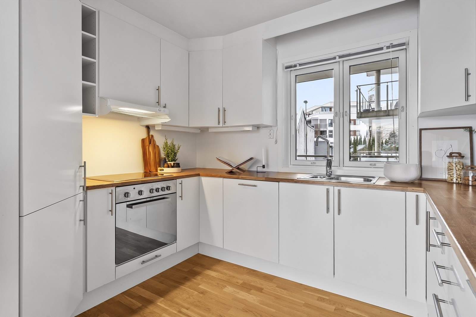 Kjøkkeninnredningen er godt tilpasset rommets utforming og har godt med skap- og benkeplass Galleribilde