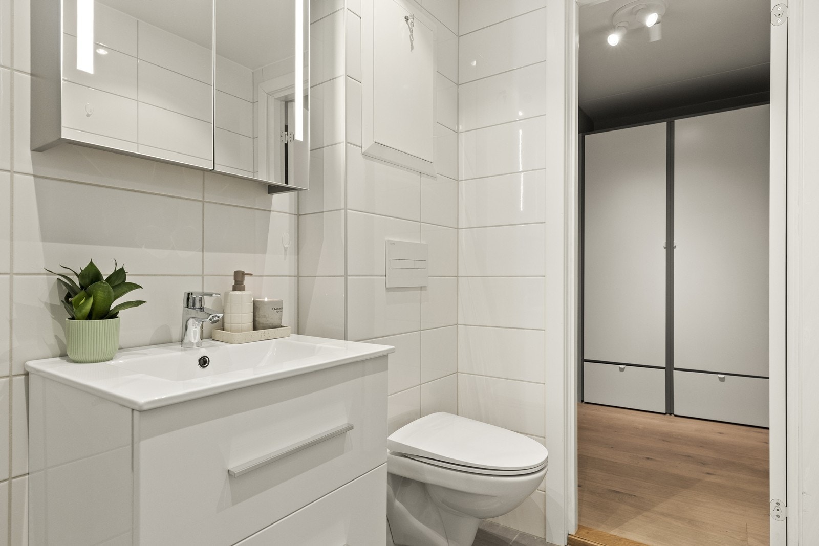 Baderomsinnredning med heldekkende servant og speilskap med integrert belysning. Galleribilde